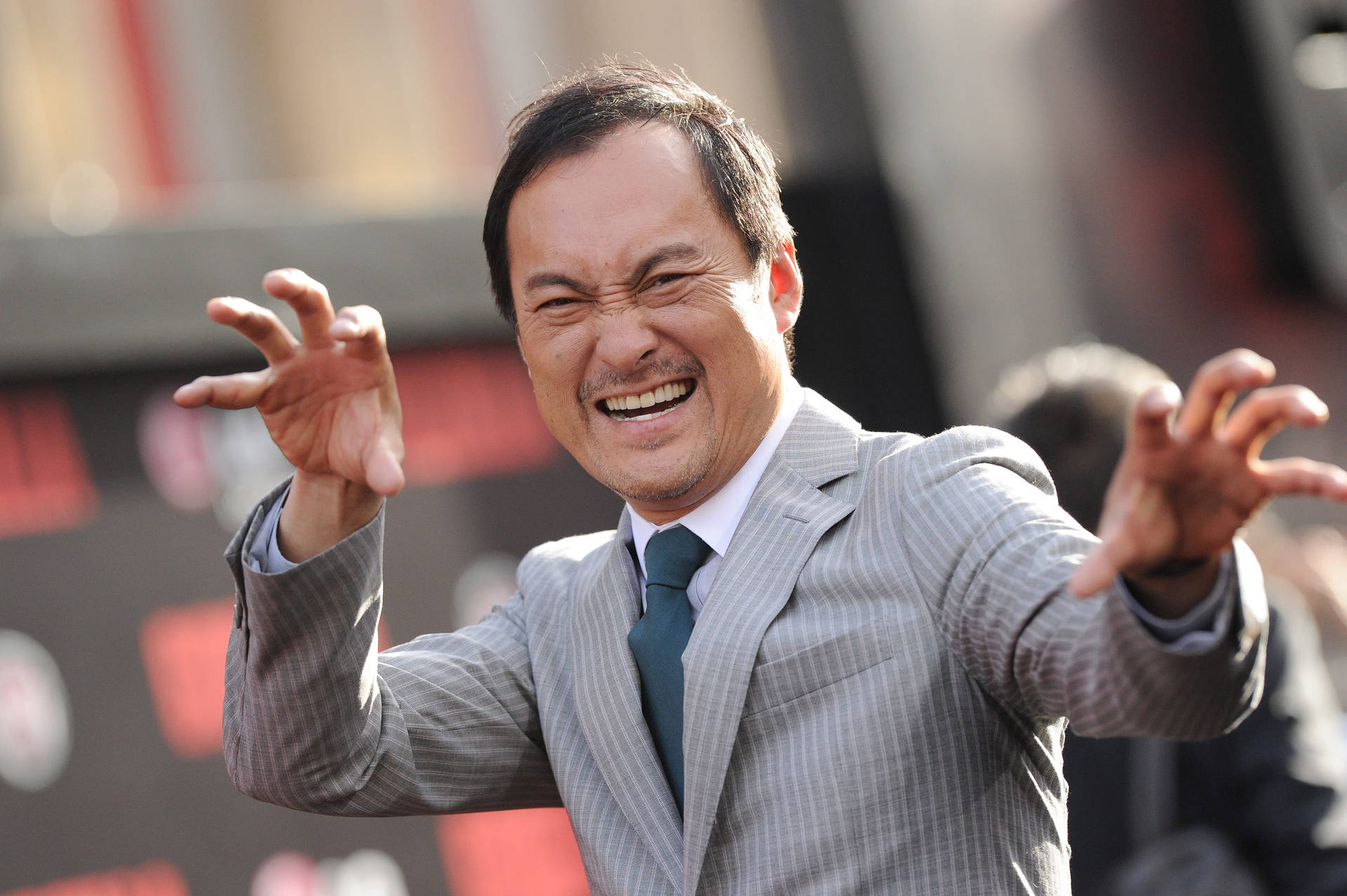 穿西裝的男子在戶外張開雙臂微笑
