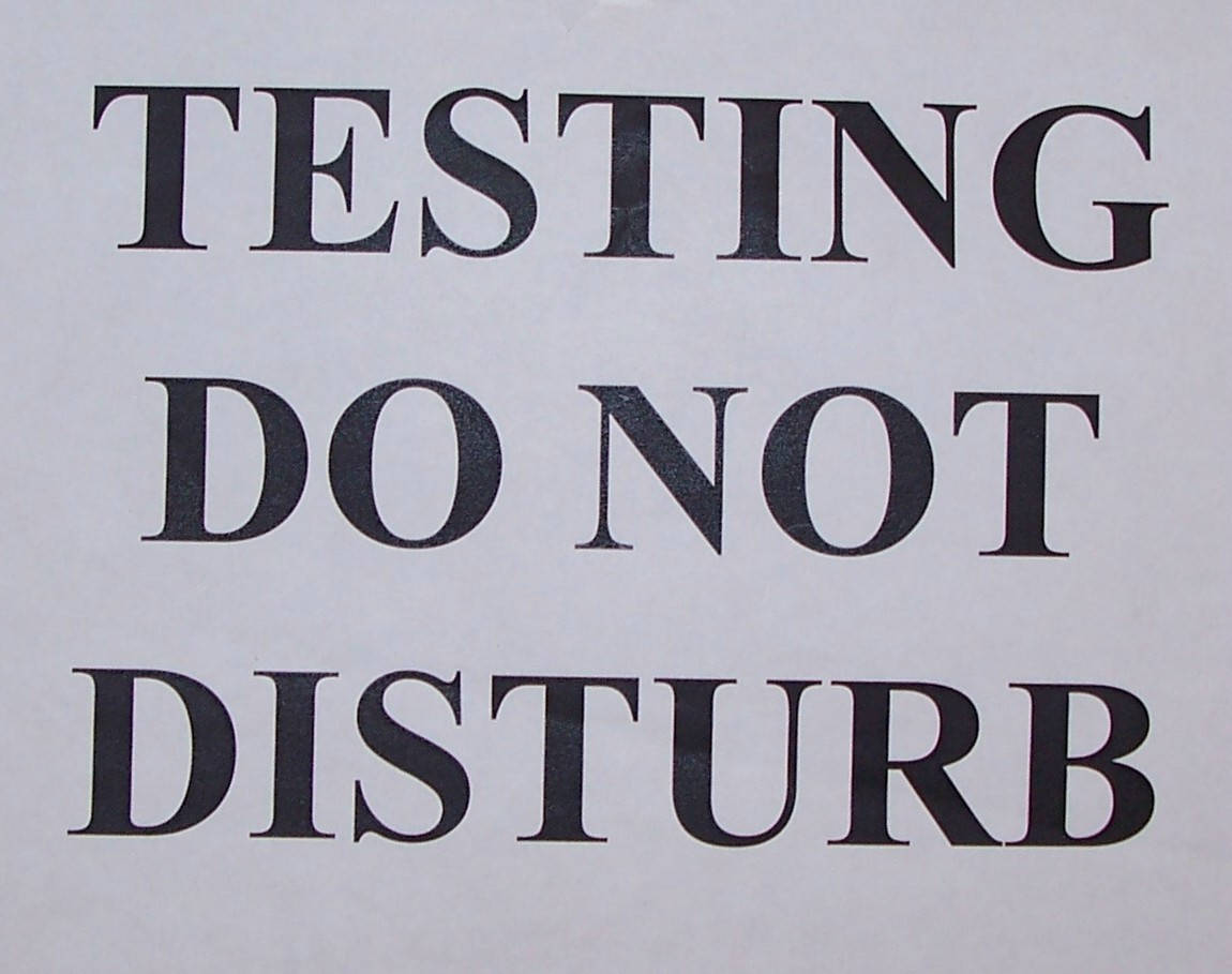 一個標誌，淺灰色紙張上以粗體黑色文字寫著 testing do not disturb。