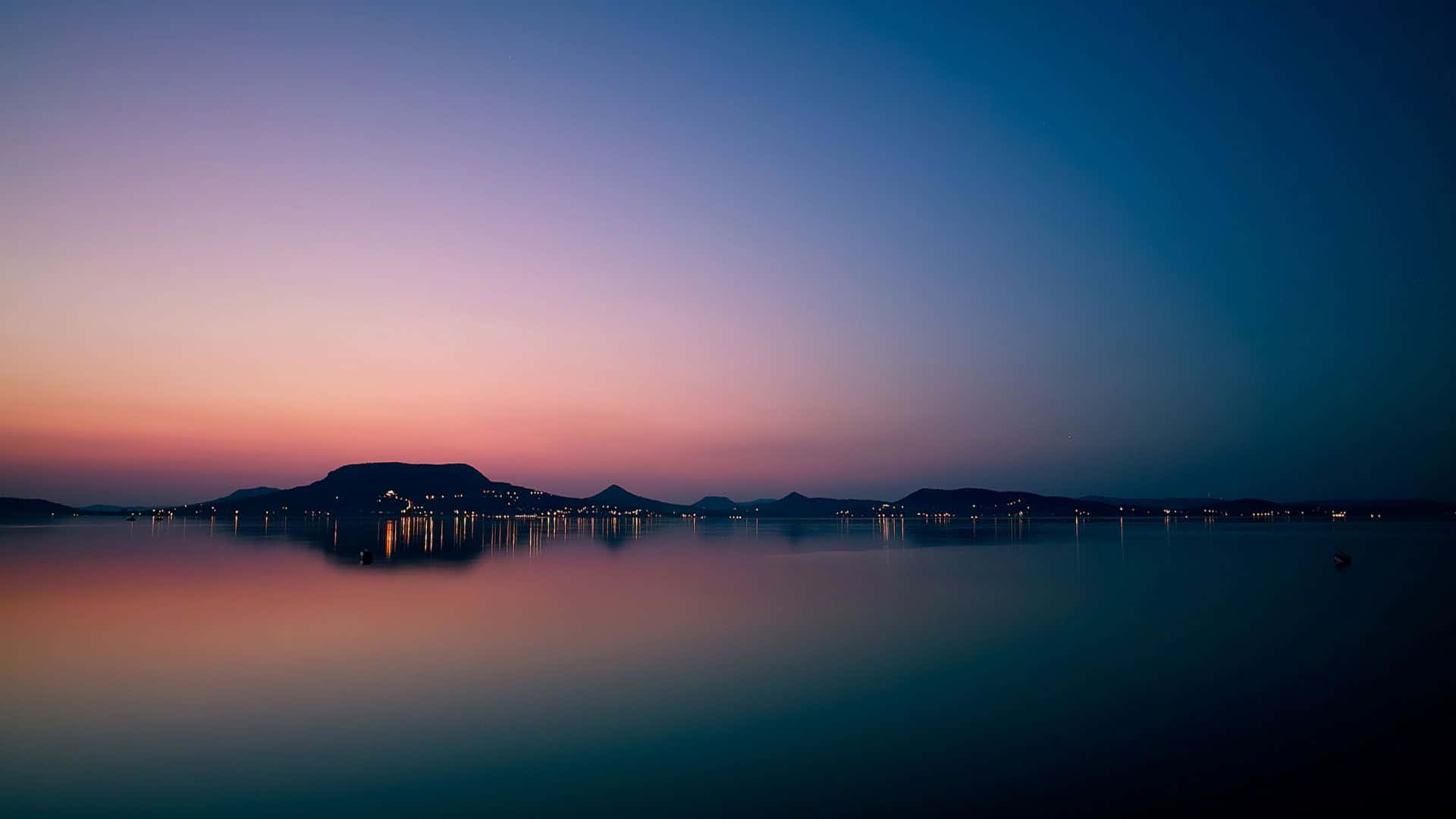 湖上日落，遠山為背景 壁紙