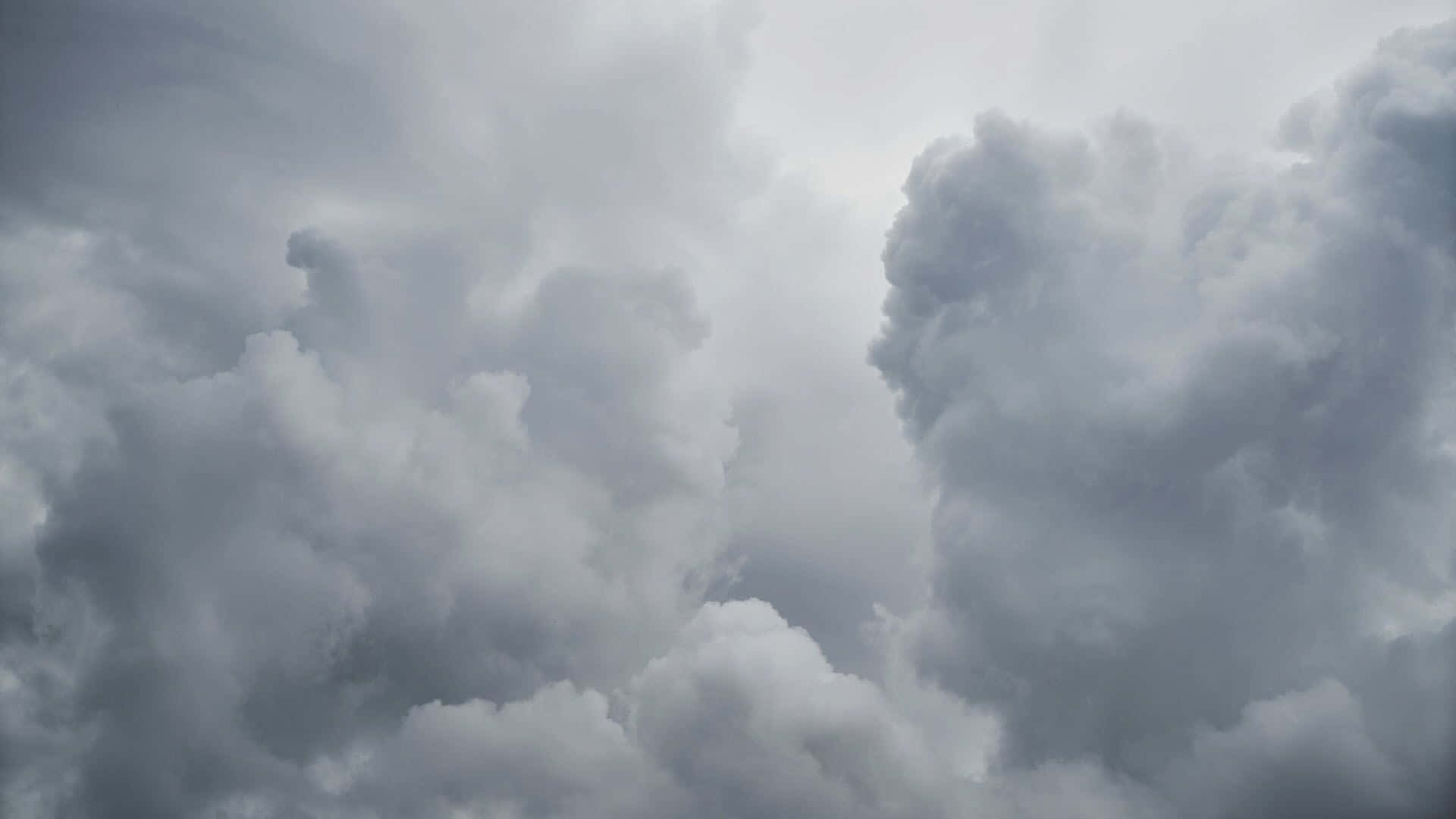 湖畔絢麗日落 壁紙 — 濃密的灰色雲層在暴風雨前的戲劇性天空中旋轉，帶有柔和的白色高光。