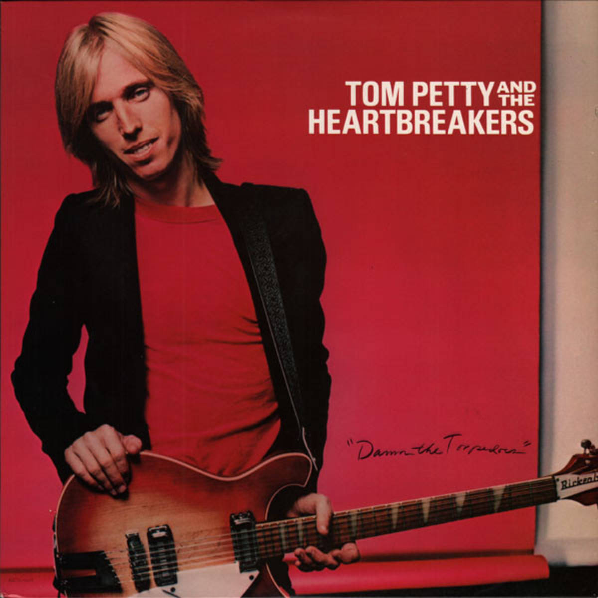 Tom Petty 在紅色專輯封面上手持結他。