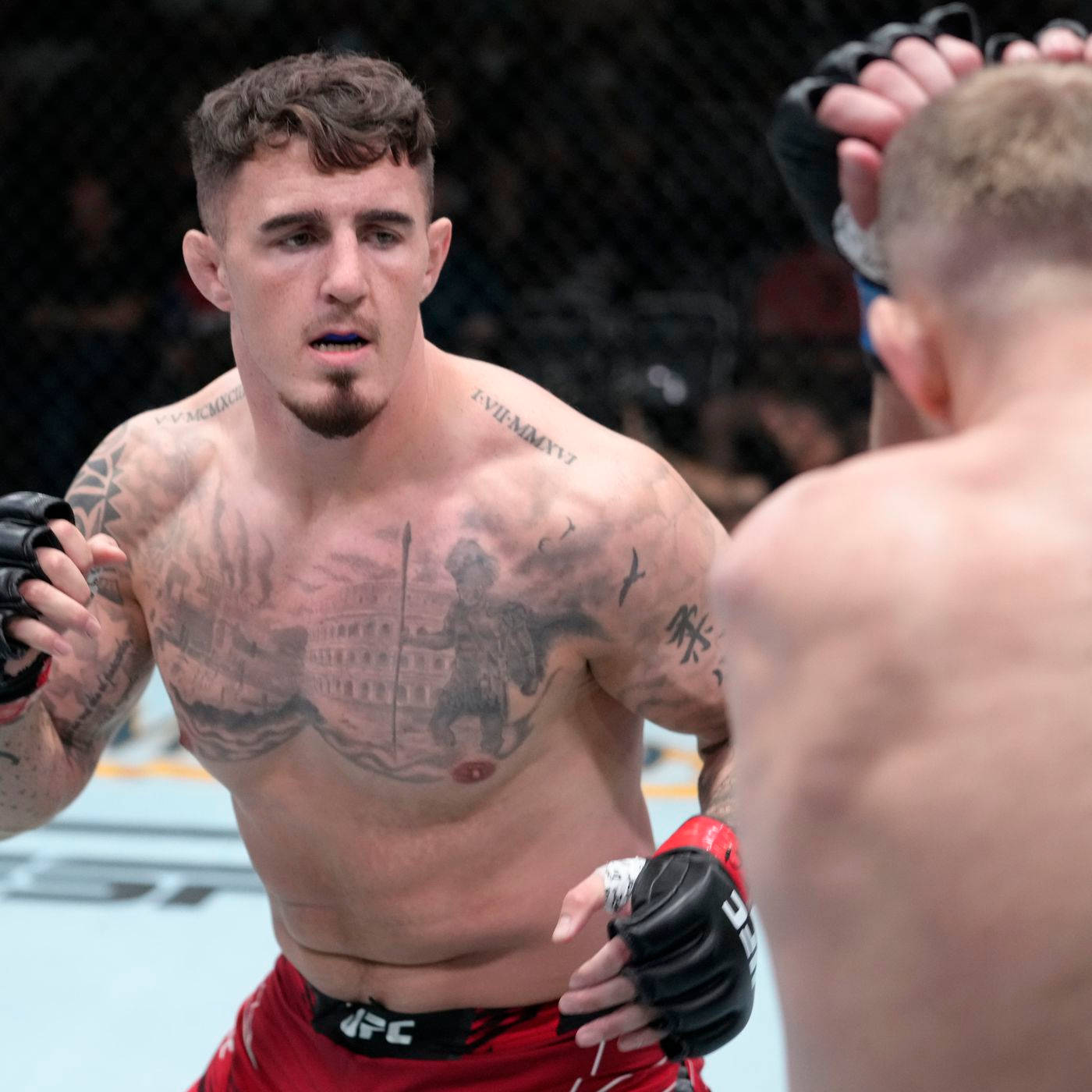 紋身MMA拳手在UFC八角籠中面對對手。