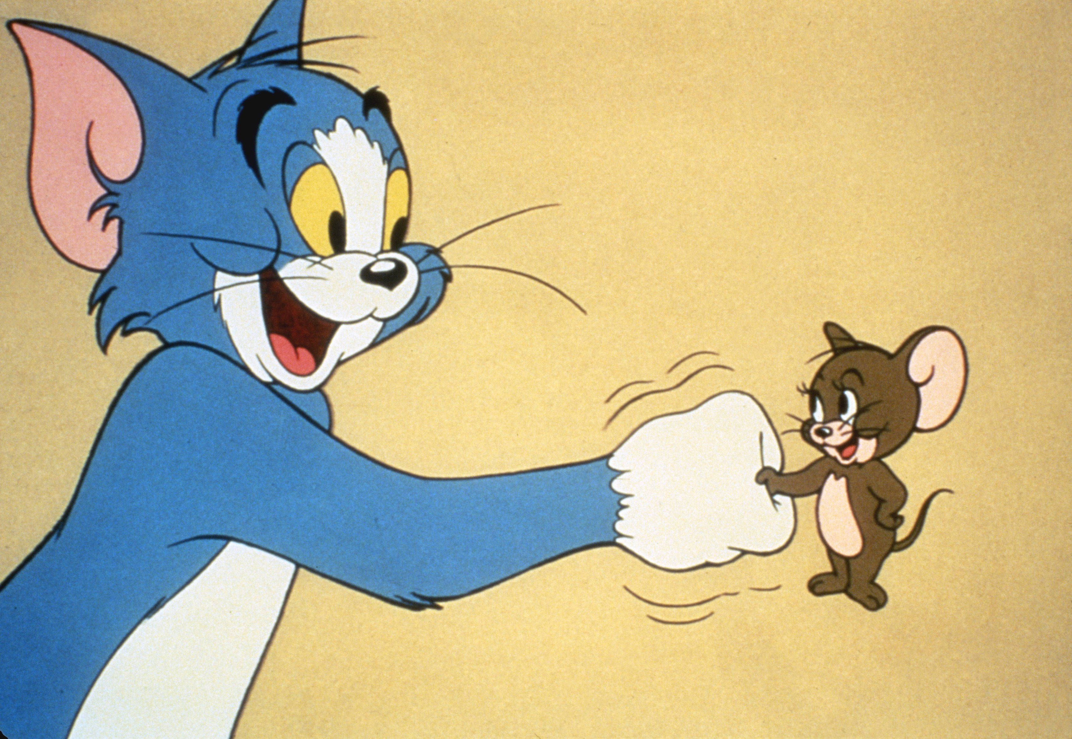 湯姆貓與傑瑞鼠 壁紙 — 經典卡通貓 Tom 快樂地打老鼠 Jerry，後者對著純米色背景笑回去。
