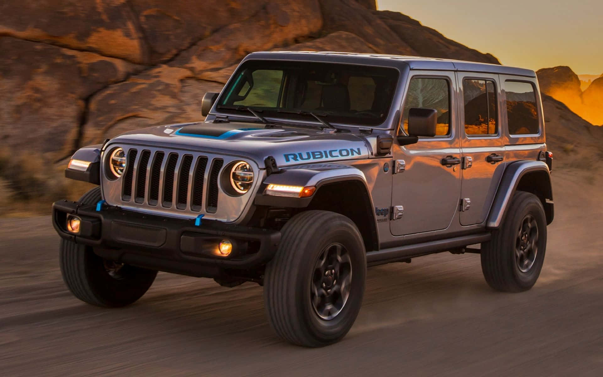 銀色Jeep Rubicon在日落時分駛過沙漠岩石，揚起灰塵。