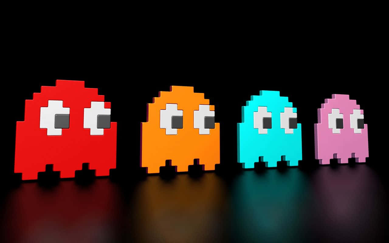 四個色彩繽紛的 Pac-Man 鬼魂在黑暗表面上排成一排。