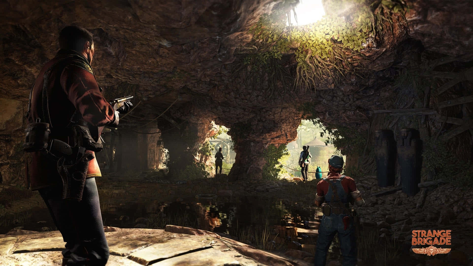 準備好武器，Strange Brigade！ 壁紙 — 探險家們穿著堅固裝備，站在陽光照射的洞穴入口，顯露出遠處茂密叢林中的人影。