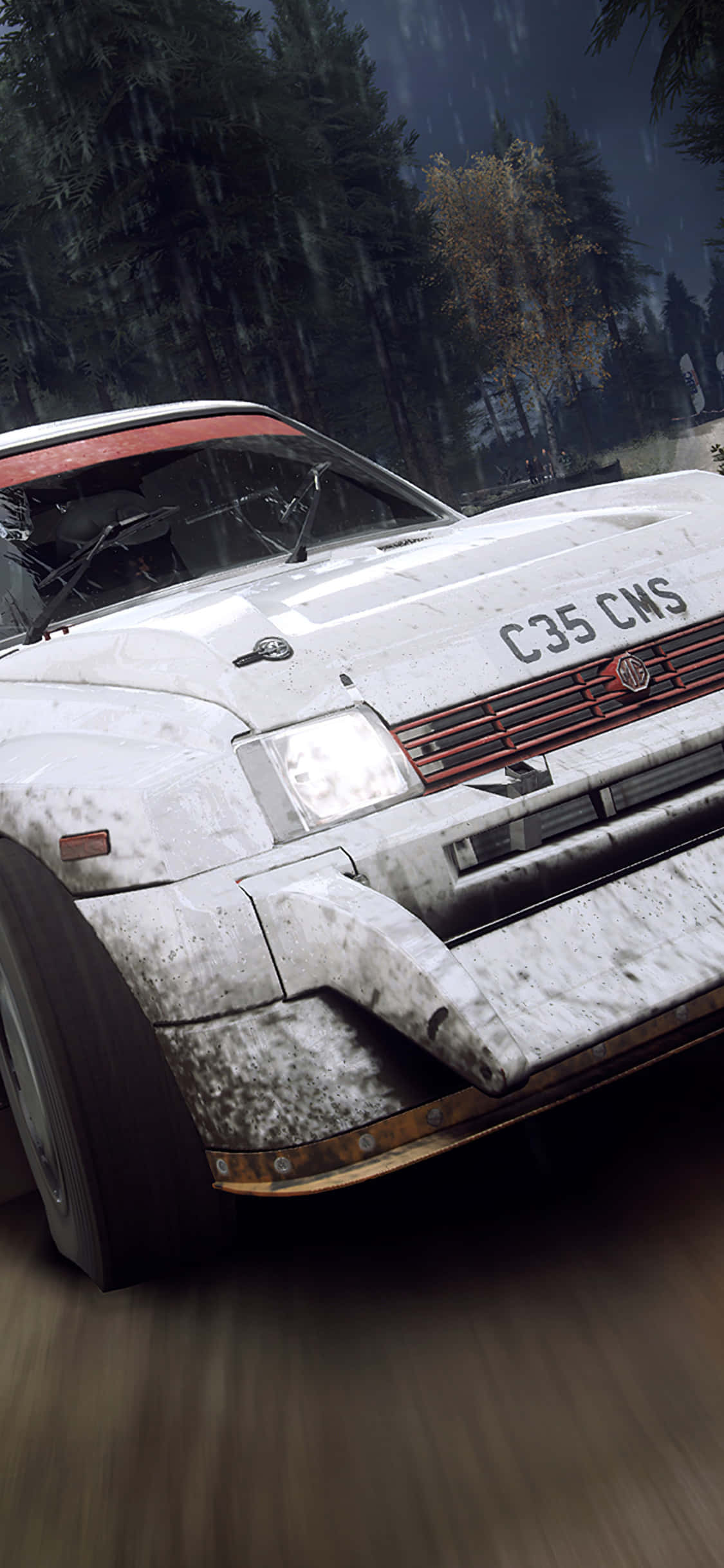 準備好用 iPhone Xs 玩 Dirt Rally 了嗎？ 壁紙 — 一輛泥濘的白色拉力賽車帶有紅色點綴，在夜間雨林中以動態模糊高速行駛。