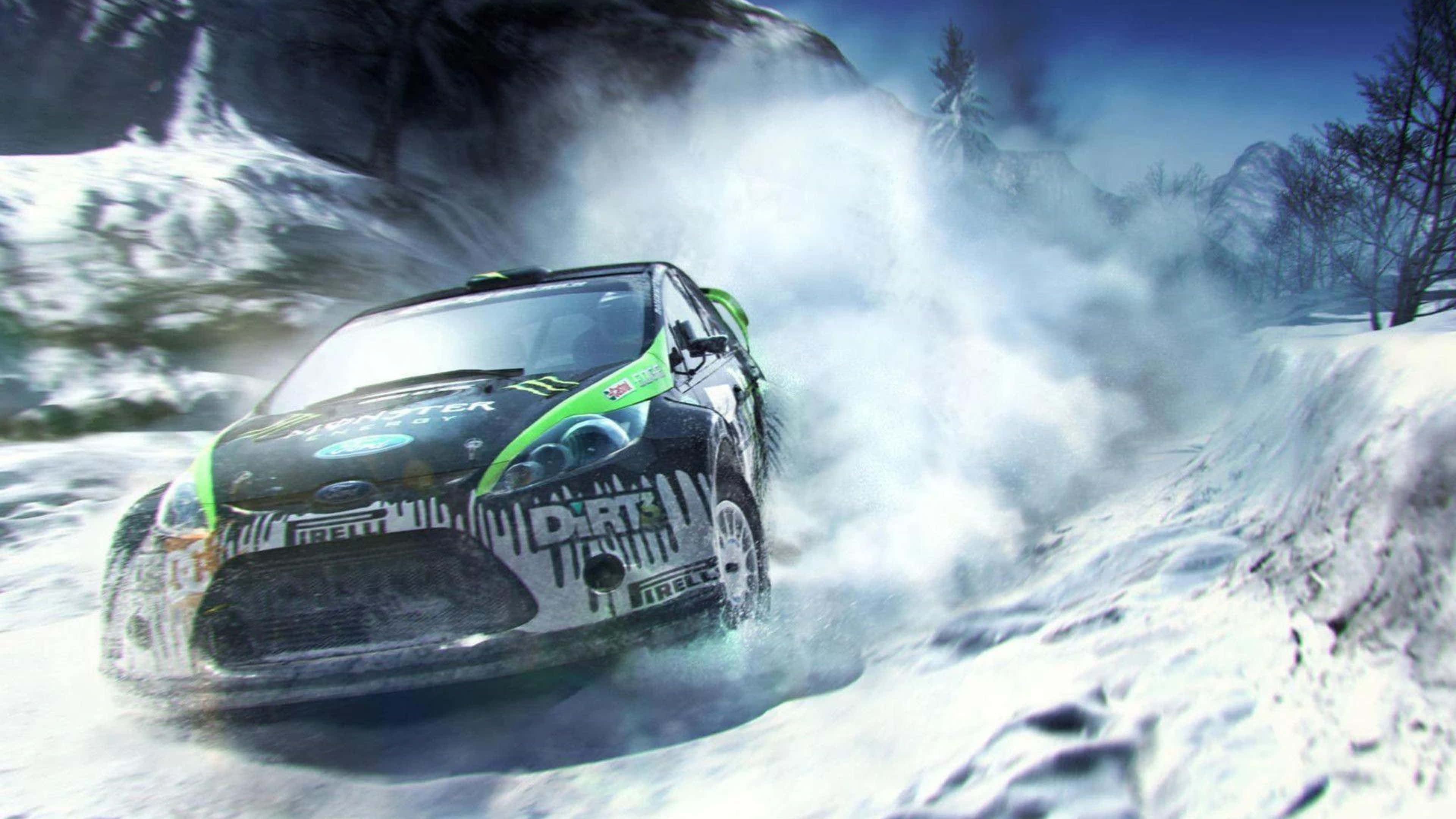 準備好迎接《DiRT 3》的驚心動魄賽事吧！ 壁紙 — 一輛綠色和黑色的拉力賽車在積雪的山口飛馳，揚起巨大的粉雪雲。