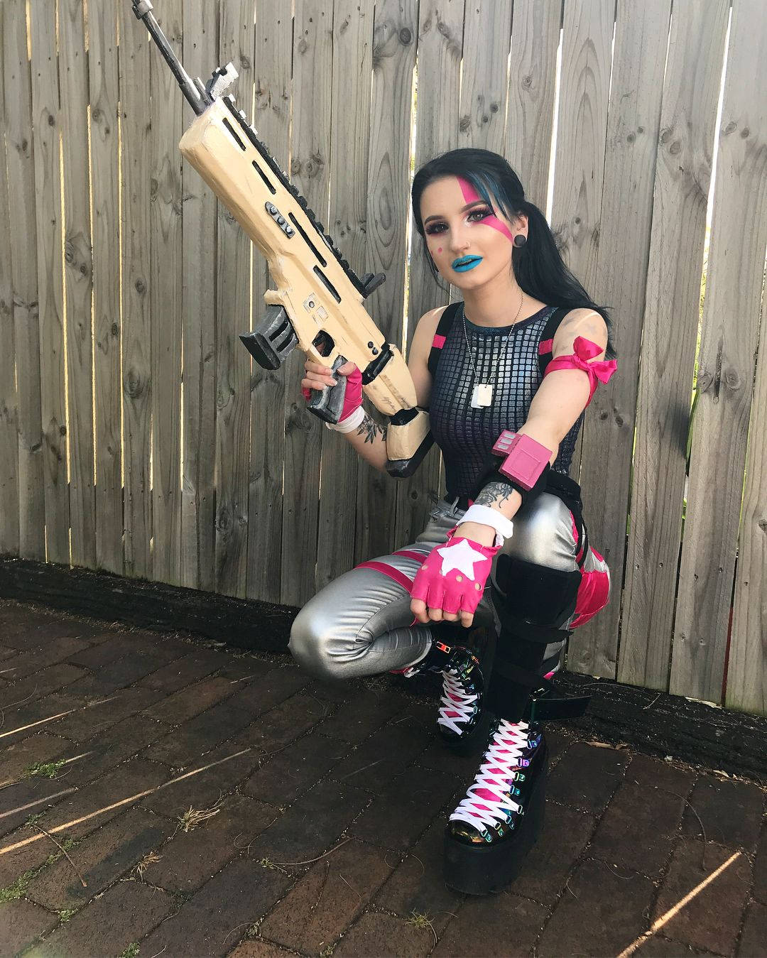 穿著哈莉·奎茵cosplay的人手持玩具槍在戶外。