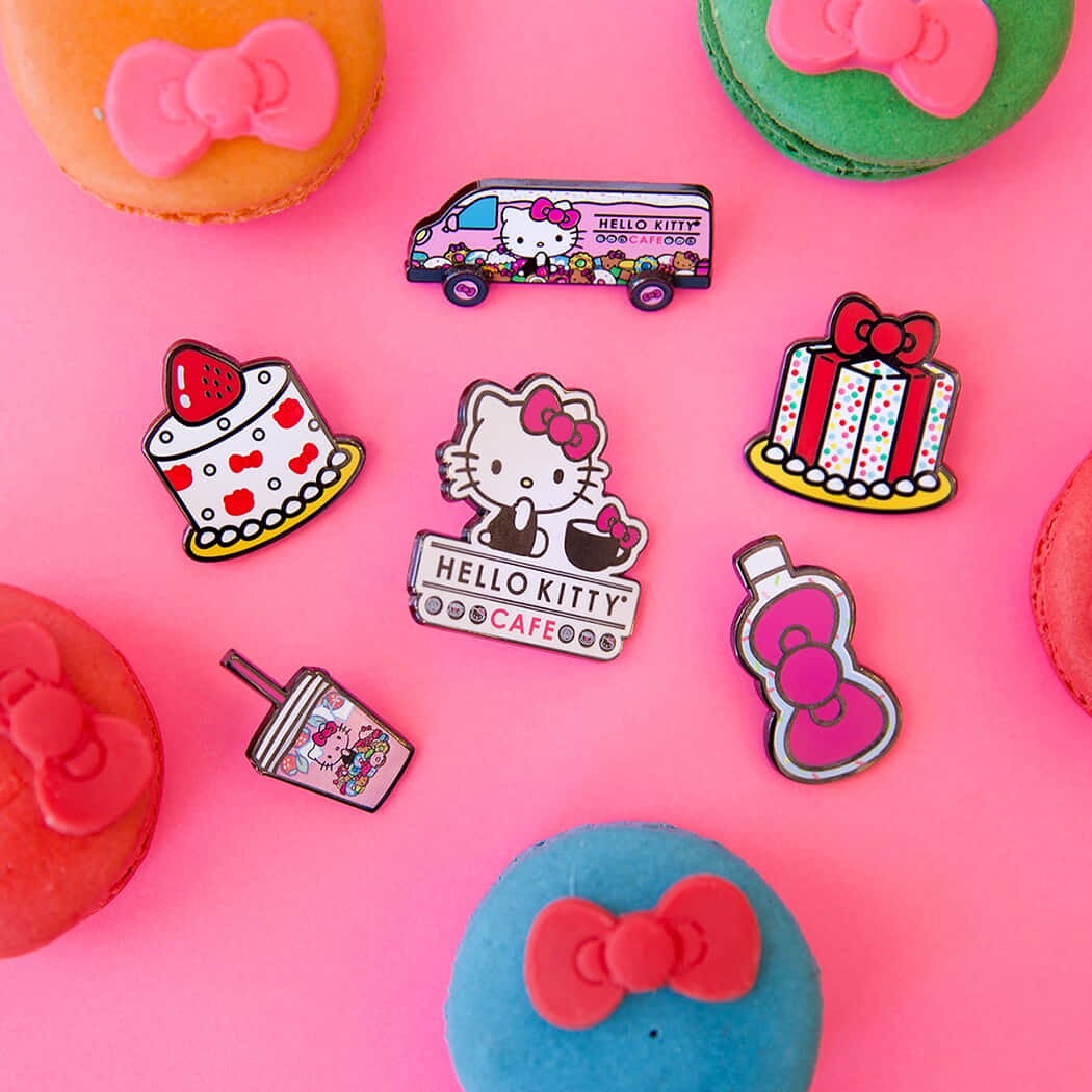 準備愛上Hello Kitty！ 壁紙 — 充滿活力的粉紅色背景，帶有Hello Kitty主題的琺瑯別針和色彩繽紛的馬卡龍，以俏皮的平鋪方式排列。