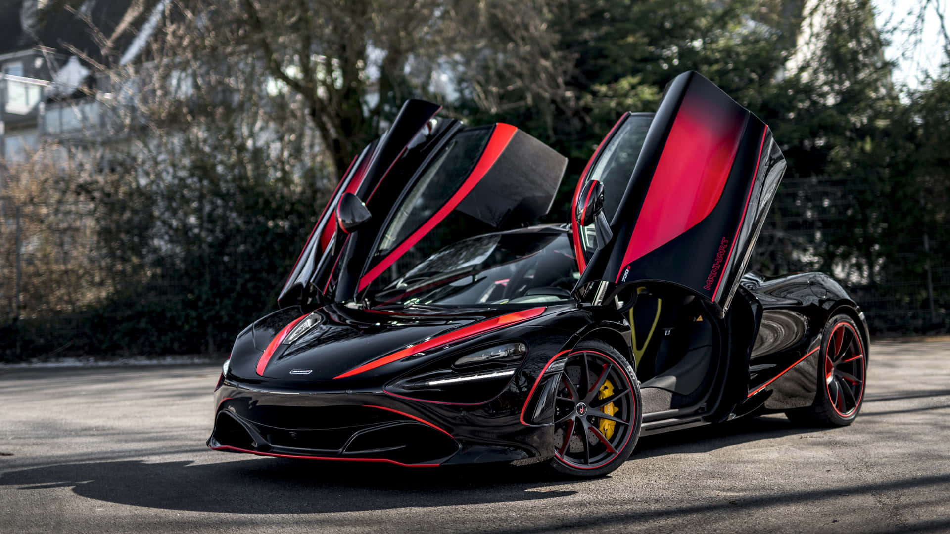 黑色McLaren跑車帶有紅色點綴和打開的車門，停泊在街道上。