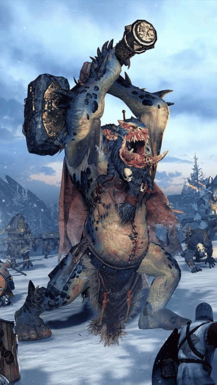 準備迎接Android《全面戰爭：戰錘2》的激烈戰鬥 壁紙 — 一個可怕的獸人 warlord 在雪地戰場上揮舞著巨大的釘頭錘，遠方有山脈，天空多雲。