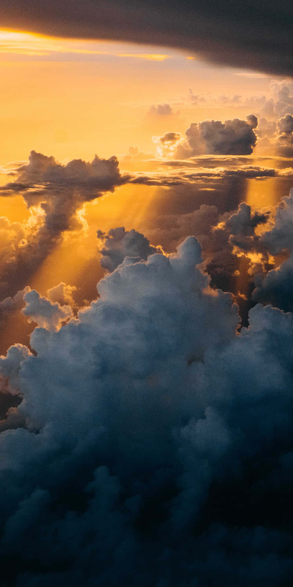 在充滿活力的日落天空中，陽光穿過雲層照耀。
