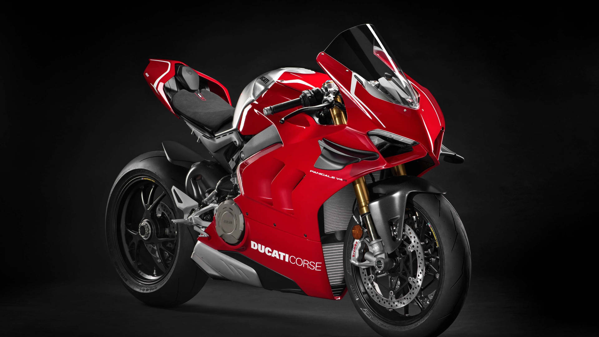 紅色Ducati Corse運動電單車，配備金色前叉和黑色飾件，在深色背景上。