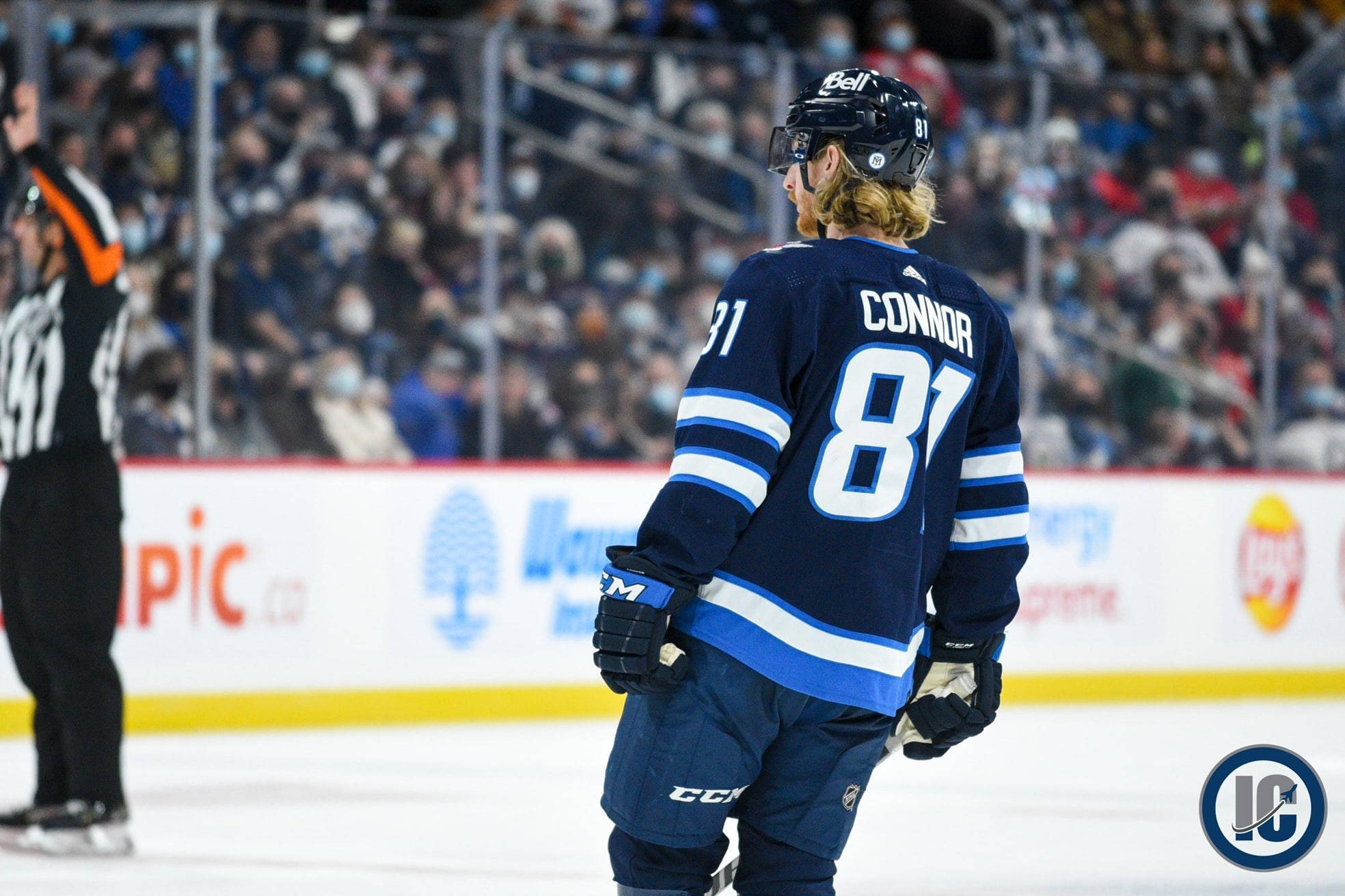 溫尼伯噴氣機隊球員凱爾·康納比賽背影 壁紙 — 身穿81號球衣的冰球運動員Connor在冰上走開，背景有觀眾。