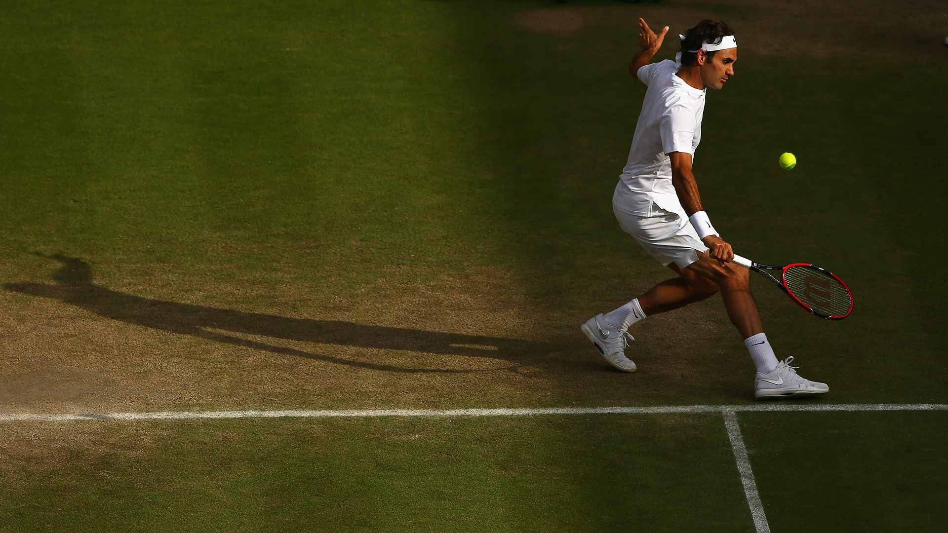 溫布頓球場與羅傑·費德勒 壁紙 — 一名身穿白色裝備的網球選手在明亮的陽光下，在草地場上飛身擊打一個黃色的球。