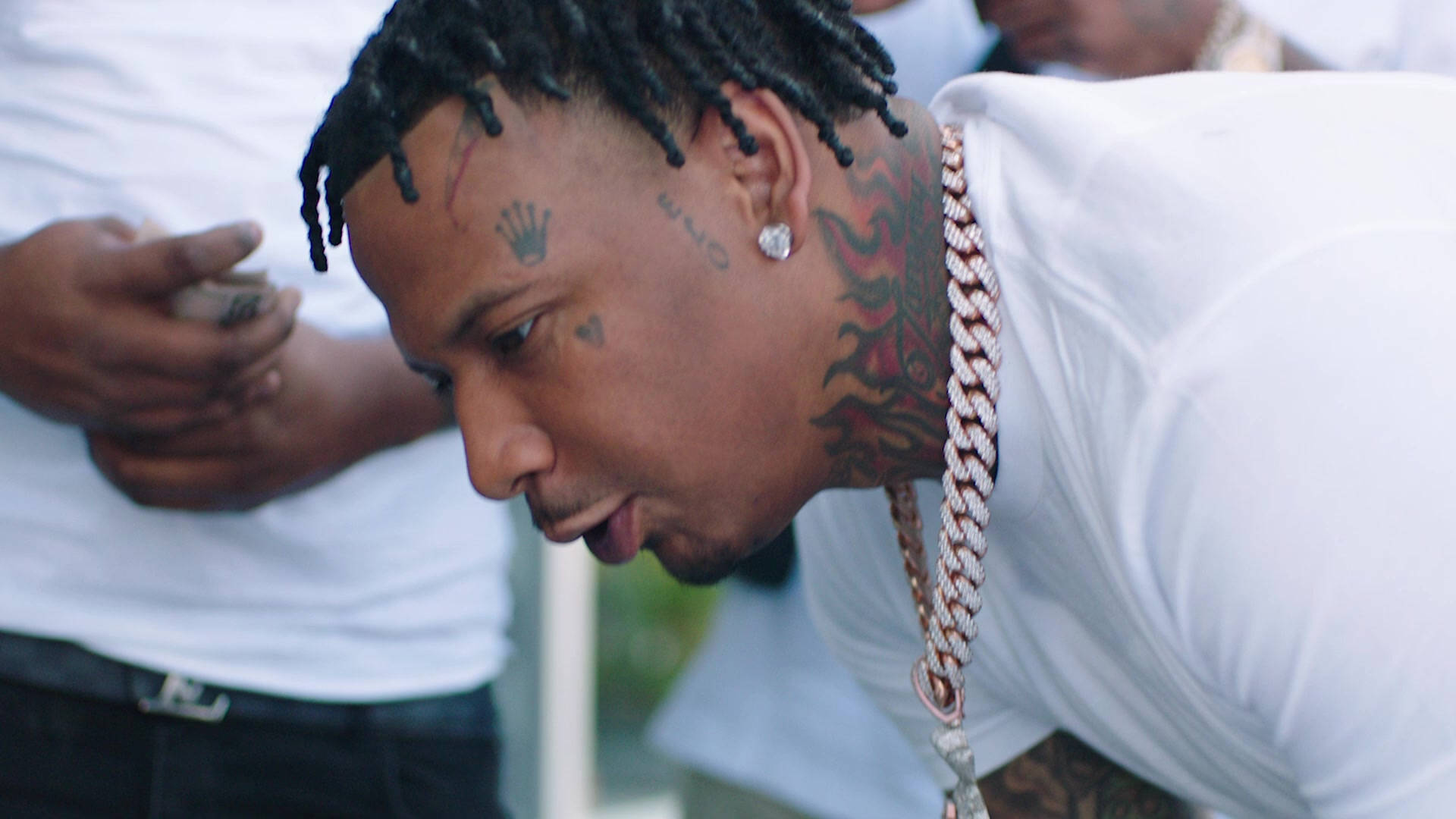 溫柔的Moneybagg Yo 壁紙 — 一名留著辮子頭髮、頸部有紋身的男子特寫，身穿白色T恤和粗鏈條。