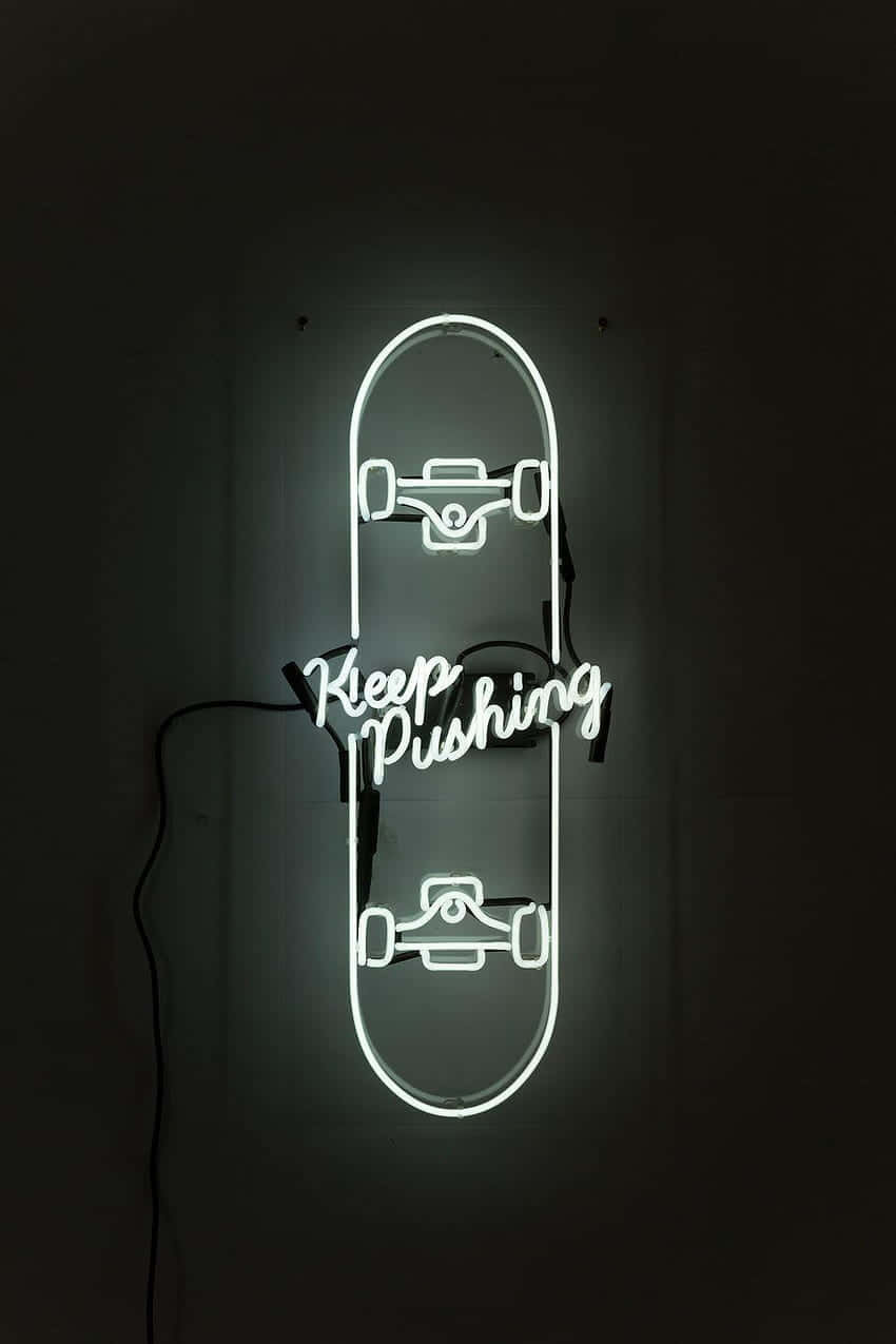 形狀像滑板的霓虹燈牌，上面寫著「Keep Pushing」，在黑暗的房間中發光。