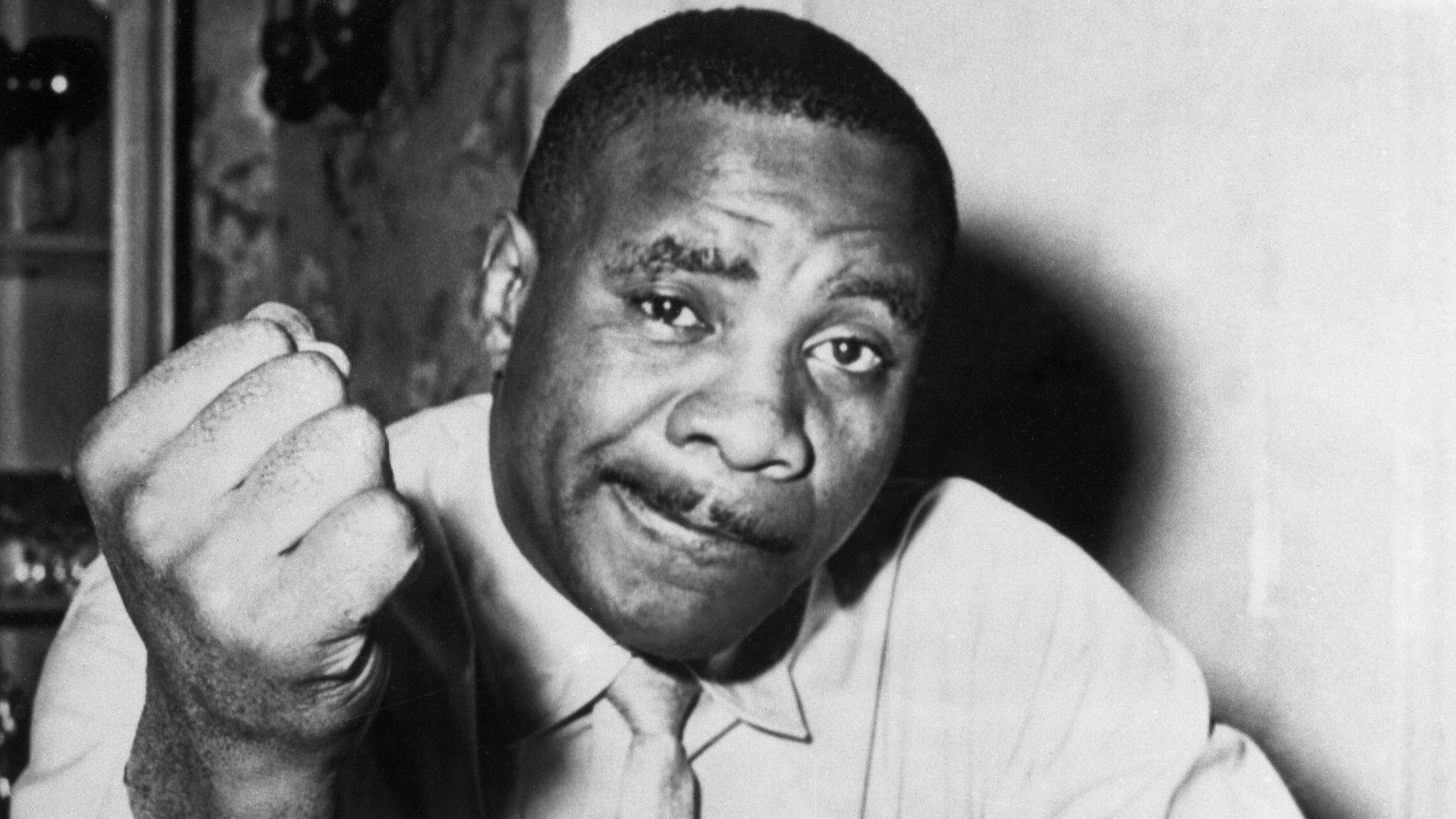 滑稽的 Sonny Liston 壁紙 — 一個留鬍鬚的男人嘅黑白肖像，佢舉起拳頭揸住支煙。