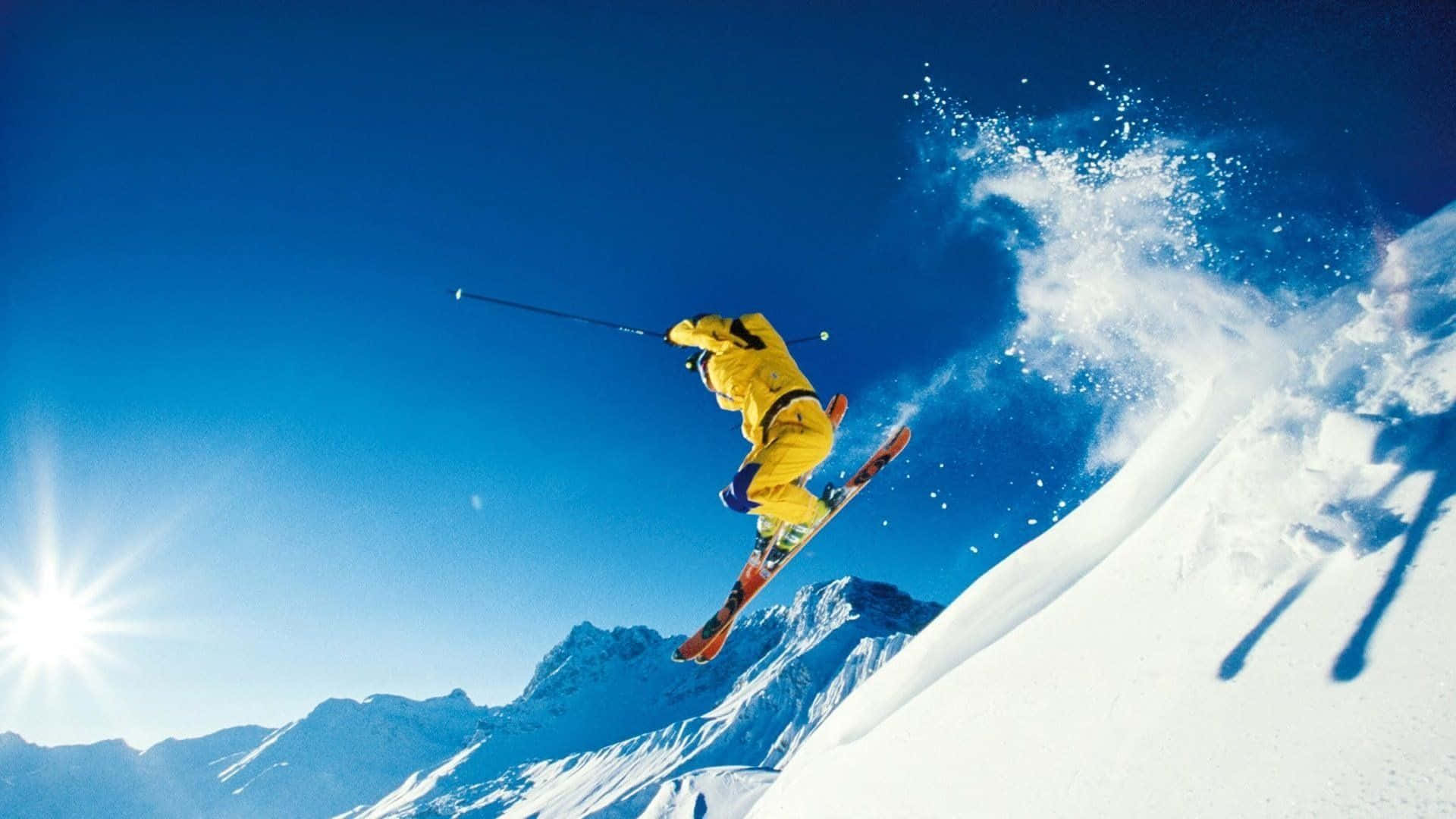 黃色滑雪服滑雪者在白雪山坡上空，陽光燦爛。