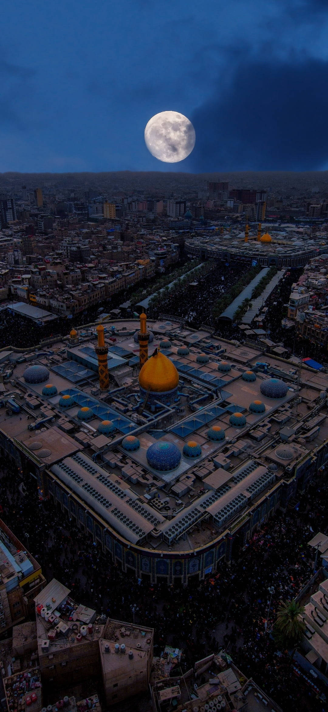 Karbala 桌布 壁紙 — 滿月下密集城市上空金色圓頂和藍色圓頂的大清真寺鳥瞰圖。