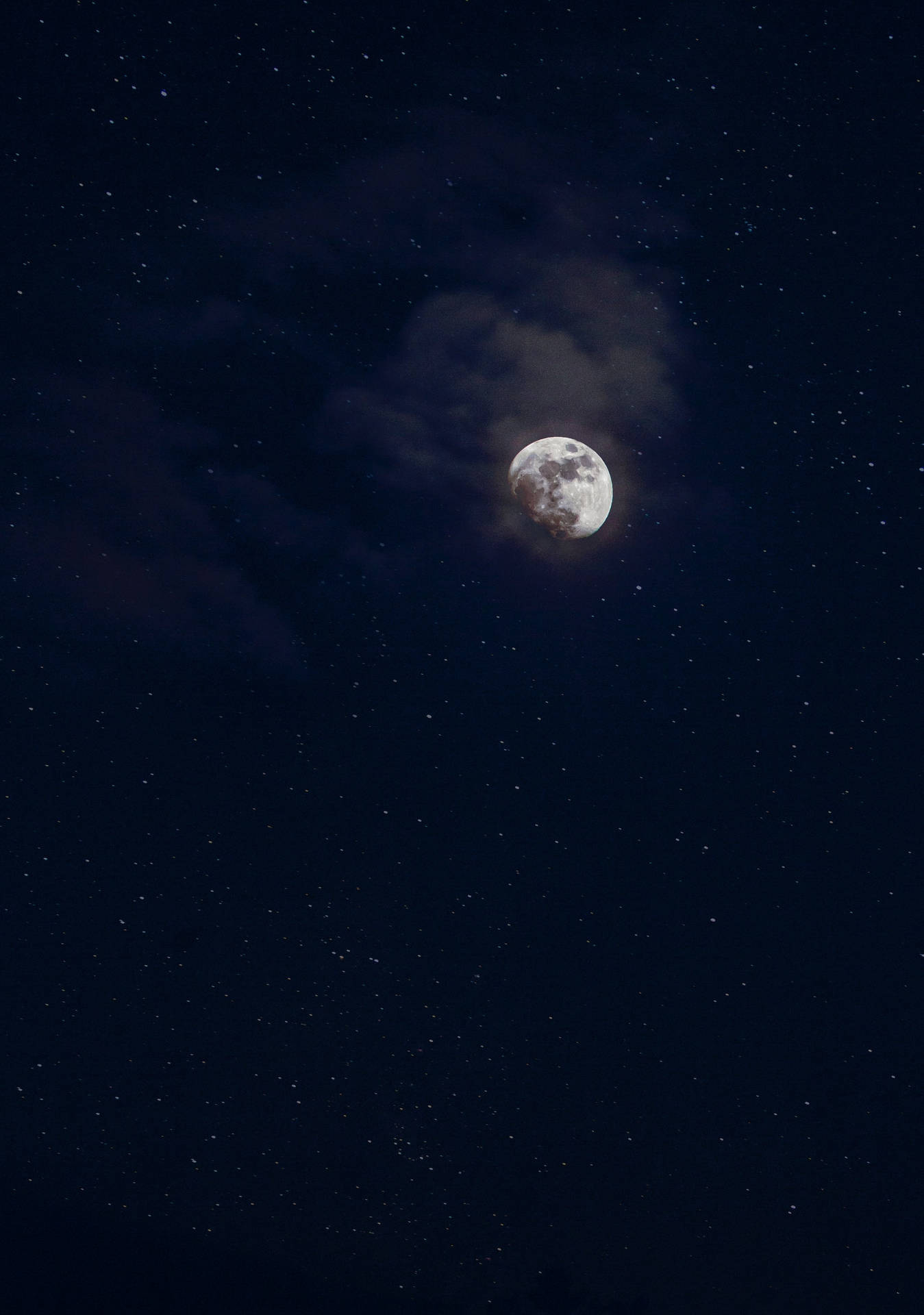 滿月在繁星點點的夜空透過雲層閃耀。
