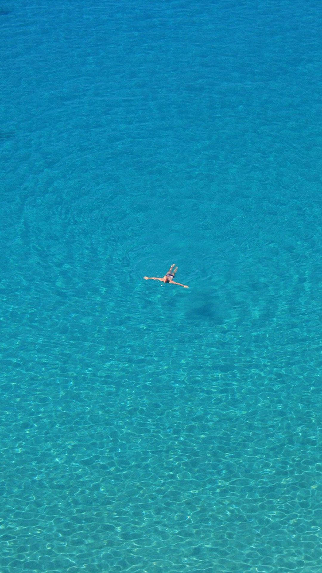 從上方看人在清澈藍色海水中游泳