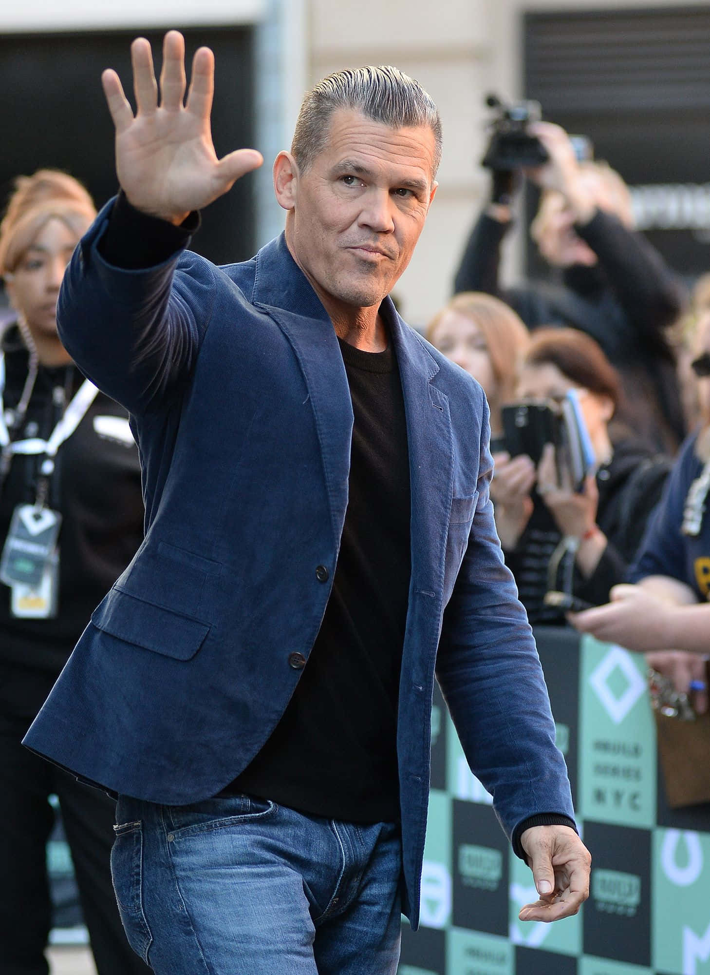 Josh Brolin 桌布 壁紙 — 演員佐斯布連在公開活動中穿著藍色西裝外套和牛仔褲向粉絲揮手，背景有攝影師。