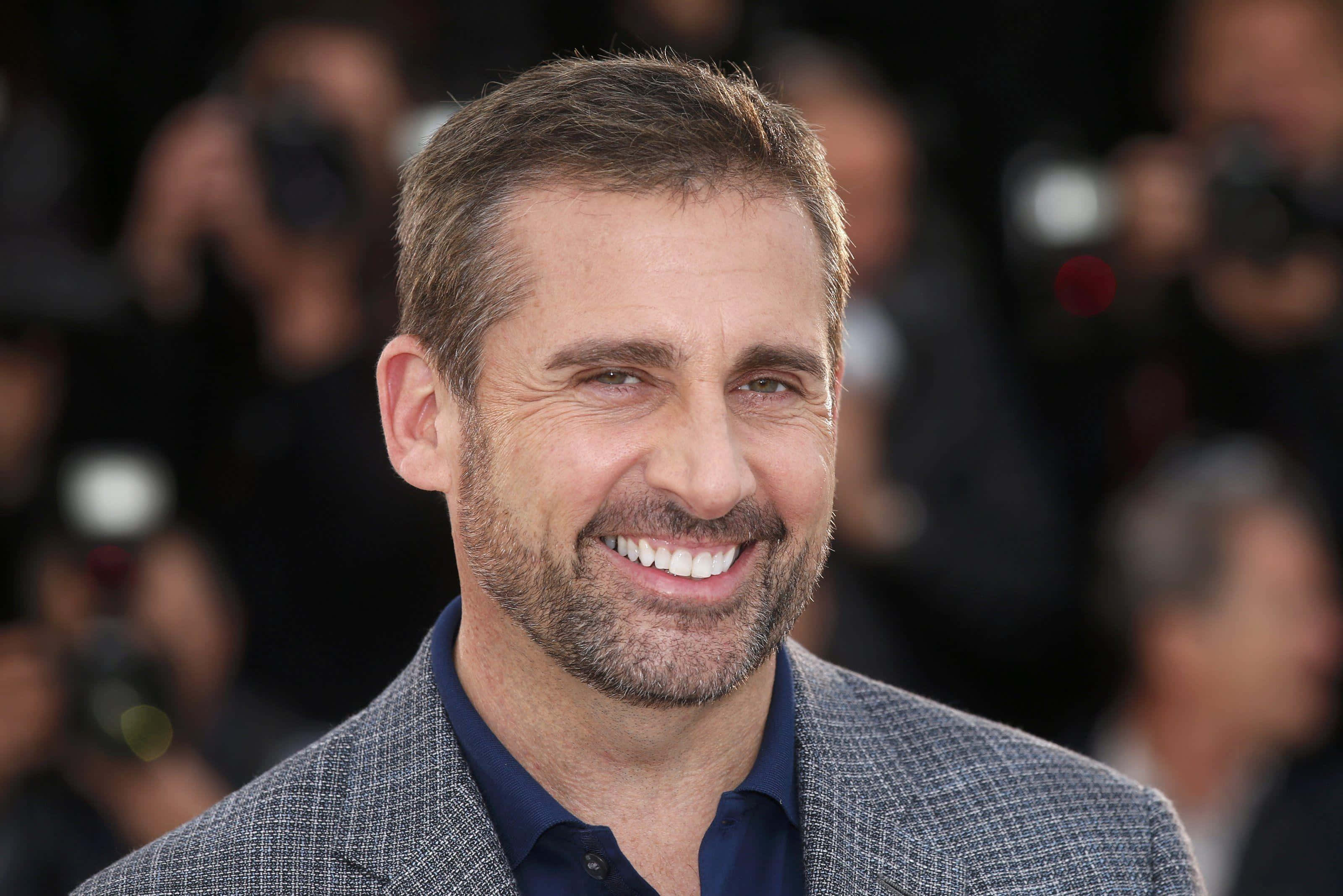 steve carell 桌布 壁紙 — 演員史提夫加維在紅地毯活動上露出燦爛笑容，背景有模糊的攝影師。