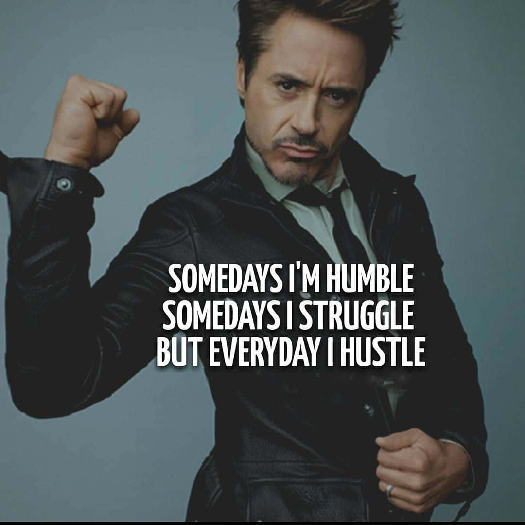 Iron Man Quotes 桌布 壁紙 — 演員羅拔·唐尼（Robert Downey Jr.）自信地穿著黑色皮褸，在柔和的灰色背景前擺姿勢，並疊加了勵志文字。