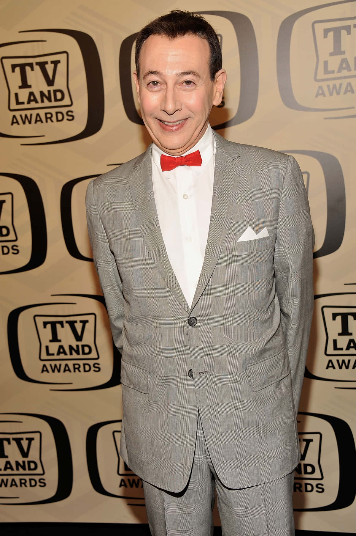 Paul Reubens 桌布 壁紙 — 演員謝利·宋飛在電視地獎紅地毯上穿著灰色西裝配紅色領結微笑。
