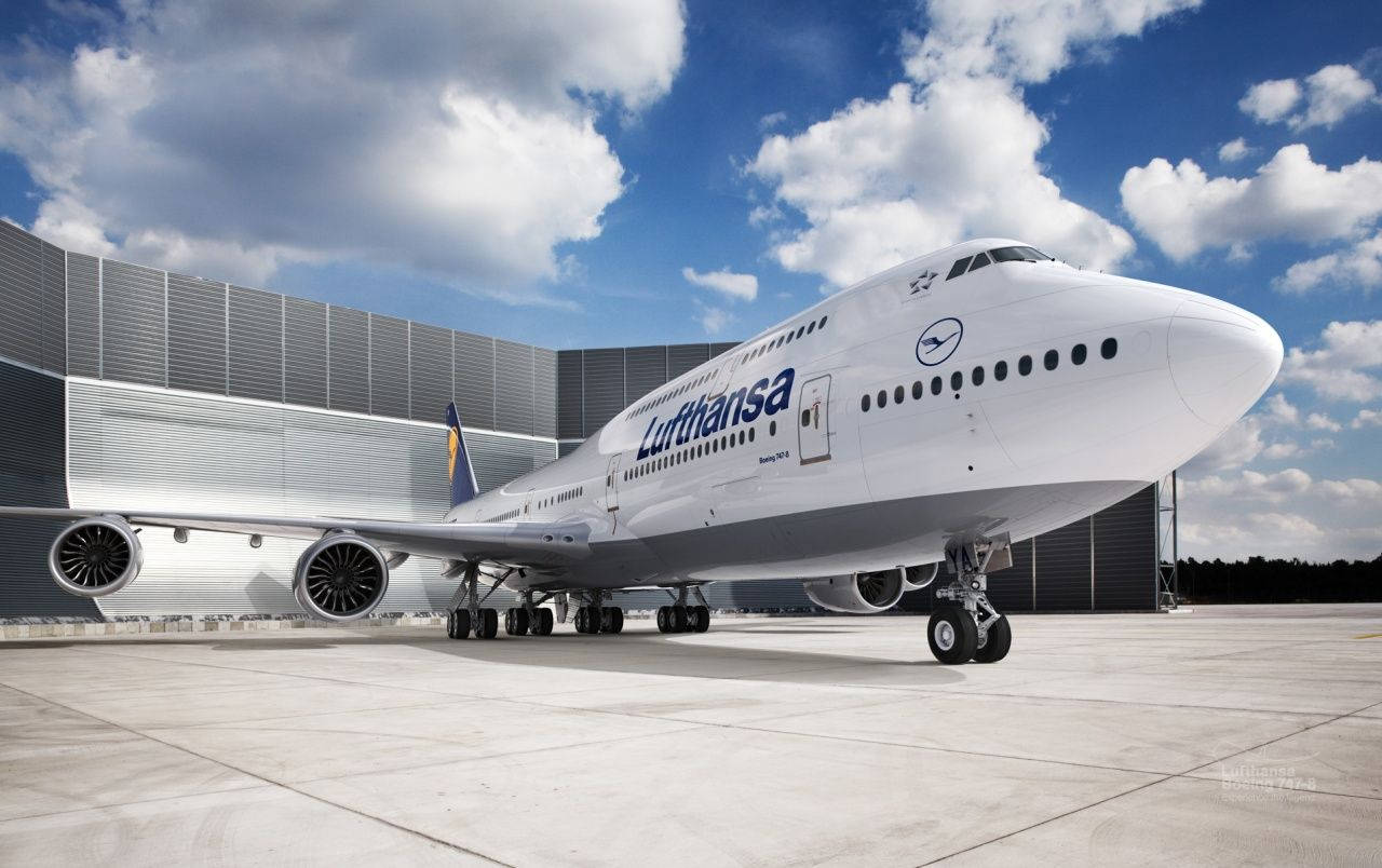 漢莎航空波音747在陽光普照、有雲的天空下停在機場停機坪。