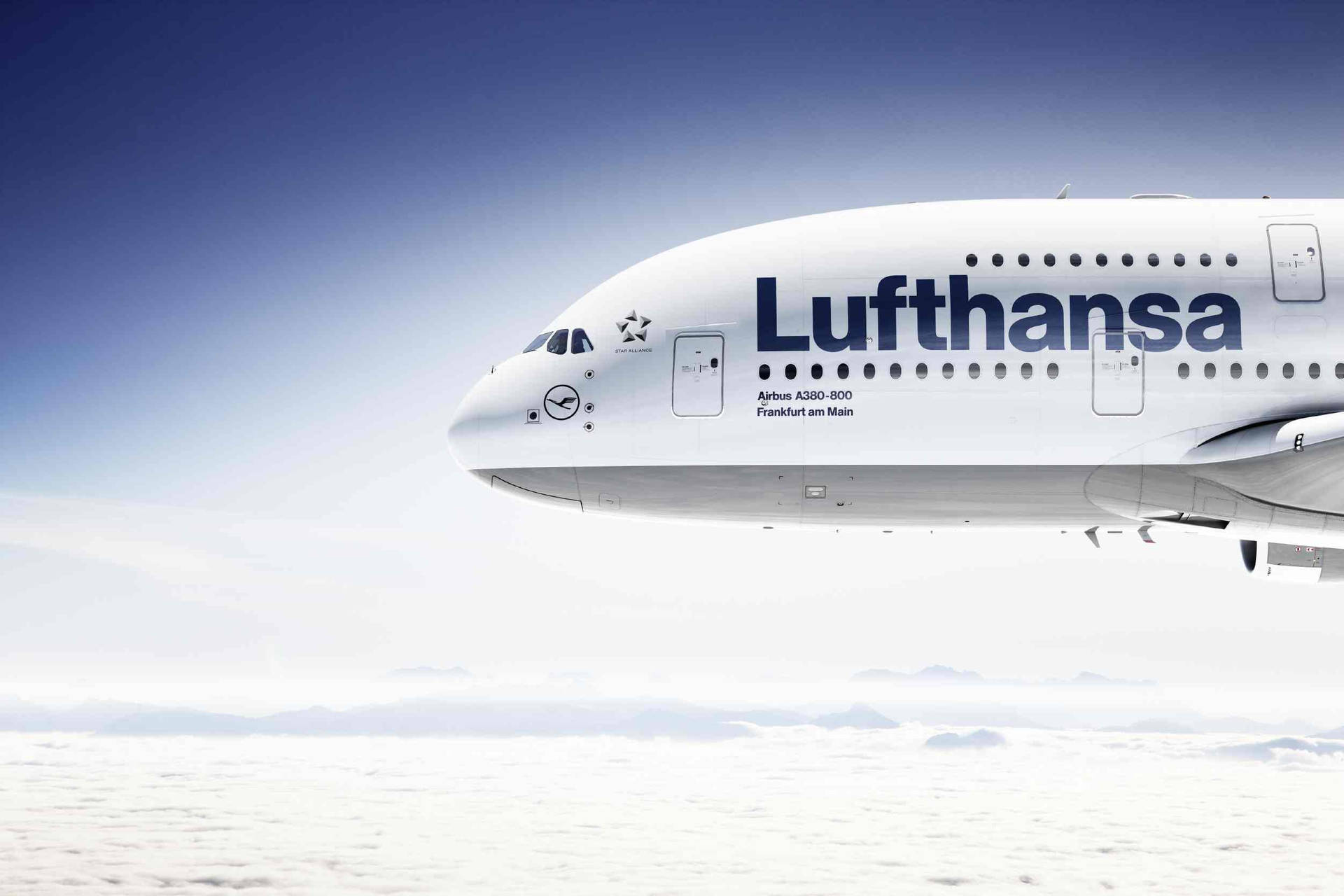 漢莎航空空中巴士A380飛越雲層，遠山在望。