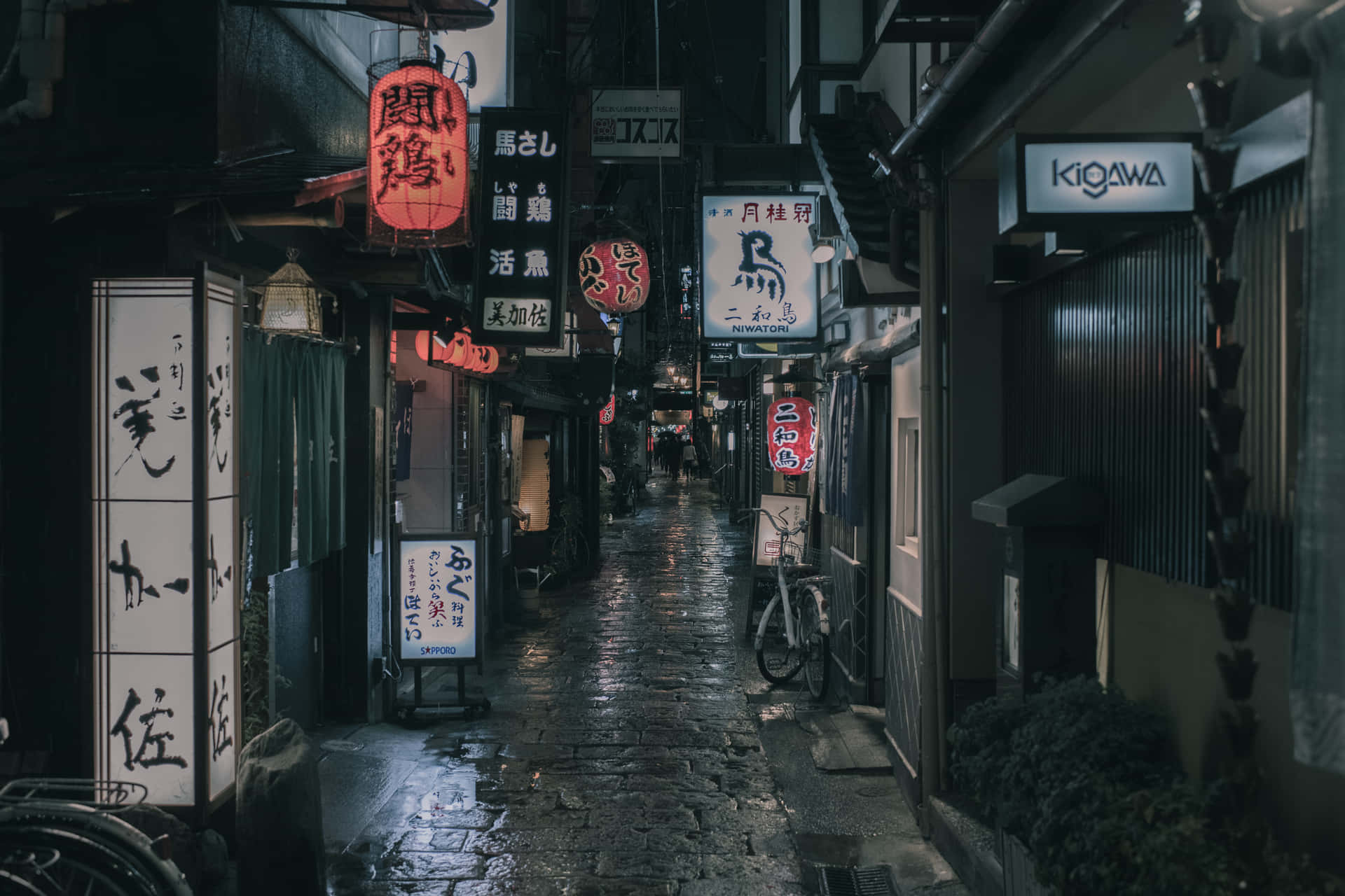京都夜晚一條狹窄濕滑的石板小巷，有發光的紅燈籠和霓虹燈。