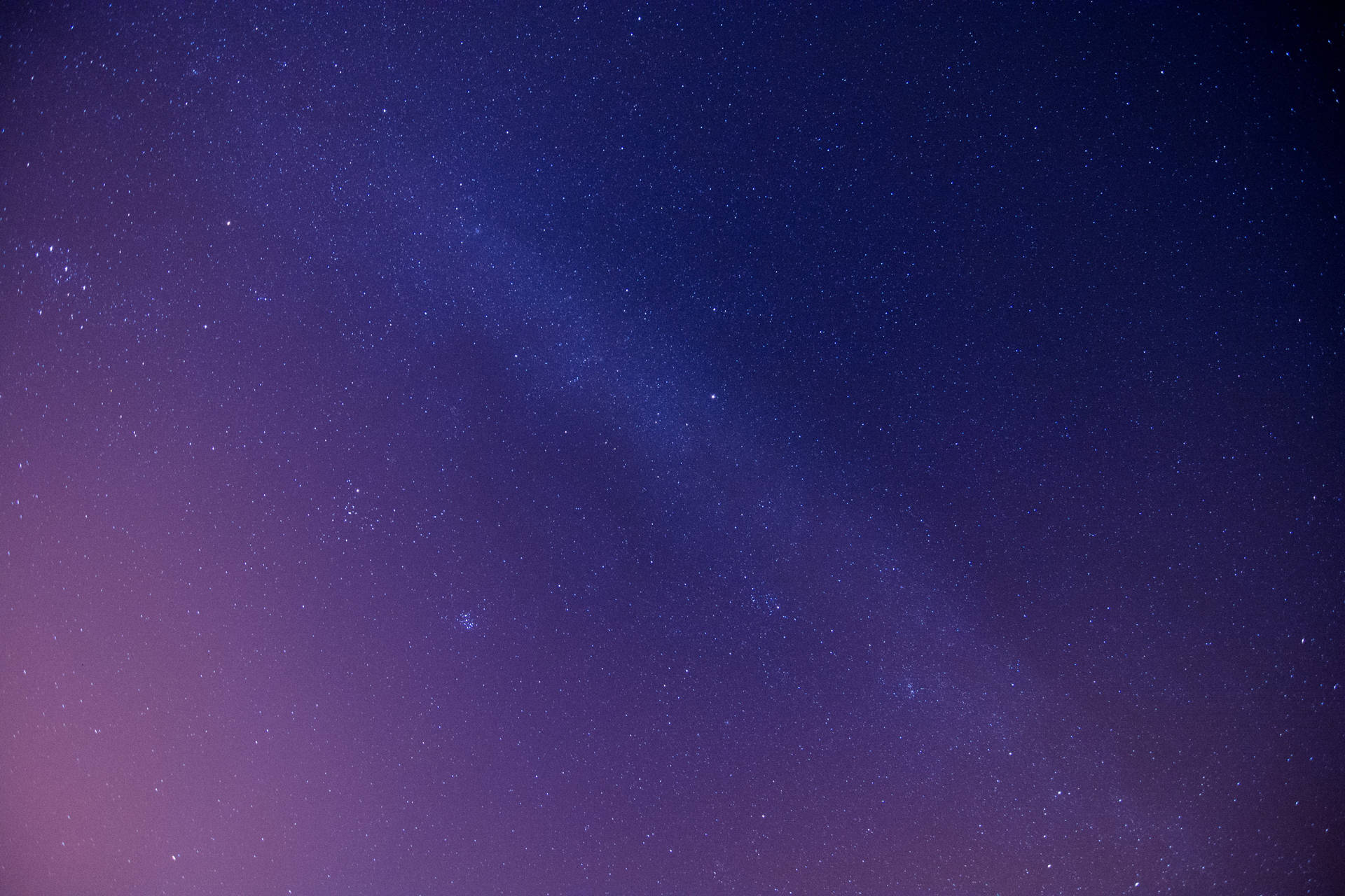 銀河系在深紫色和藍色的夜空中閃耀，伴隨著無數星星。