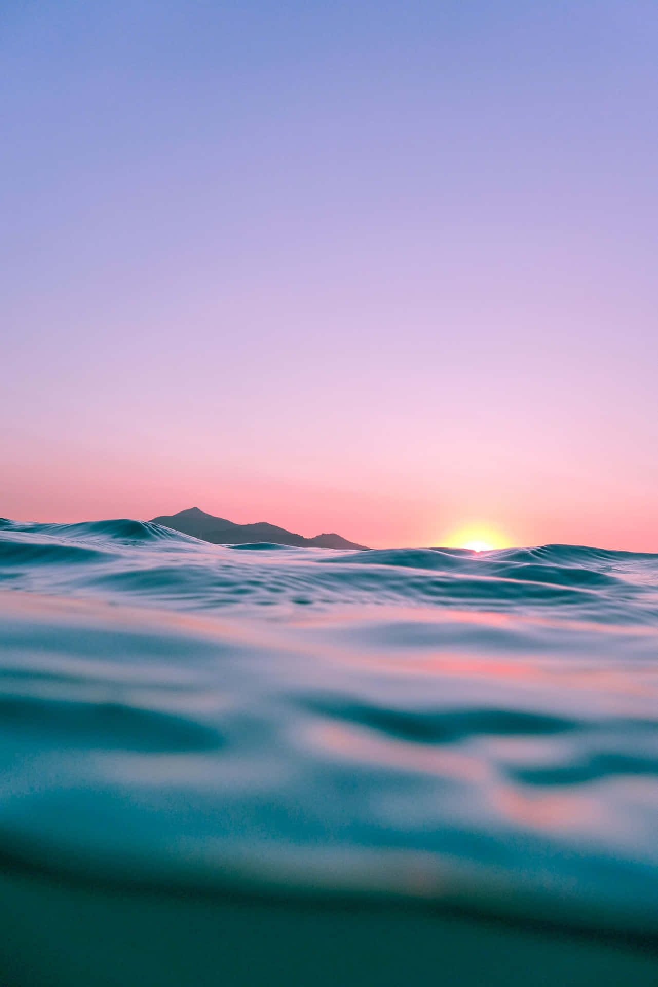 夕陽映照海洋，遠山和漣漪水面