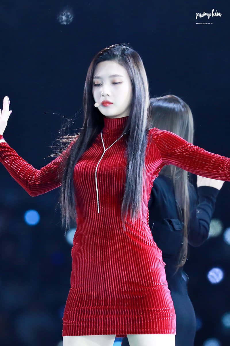 潛入紅色的世界 壁紙 — 一位身穿搶眼紅色羅紋連衣裙的女表演者在黑暗的舞台上跳舞，身後有發光的藍色燈光。