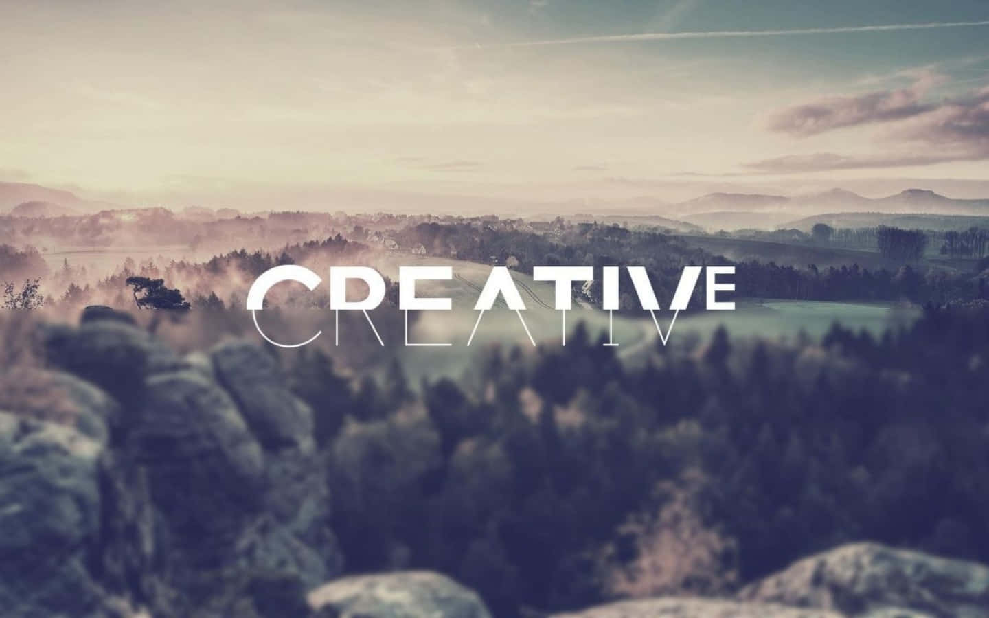 黎明時分霧氣瀰漫的山谷，帶有「CREATIVE」文字覆蓋。