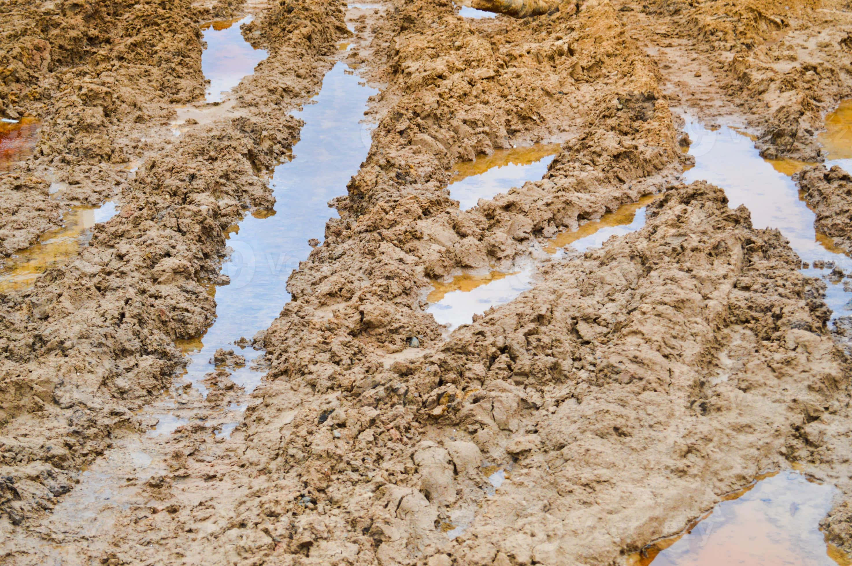 mud 桌布 壁紙 — 潮濕泥濘地形的特寫，反射的水坑揭示了天空和地面的紋理。