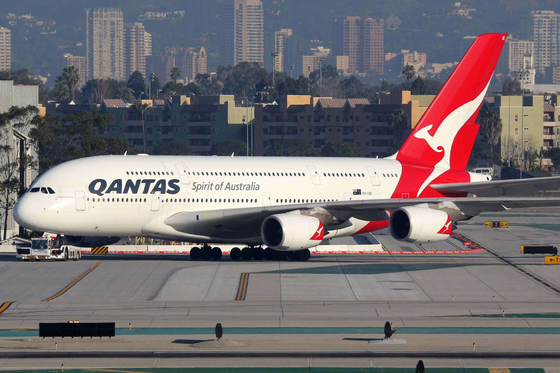 澳洲航空空中巴士A380停在機場停機坪上，背景是城市天際線。
