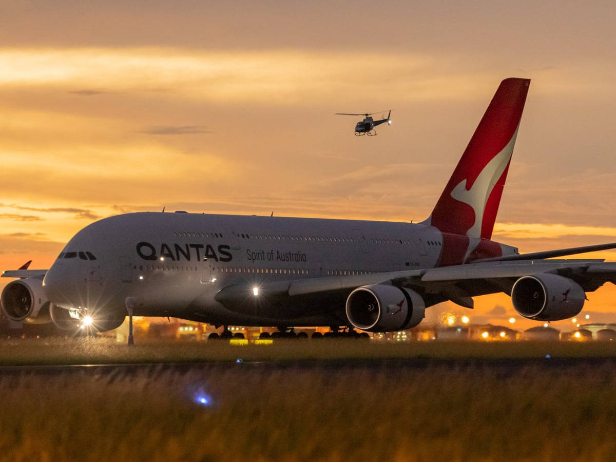 日落時 Qantas Airbus A380，直升機飛過頭頂。