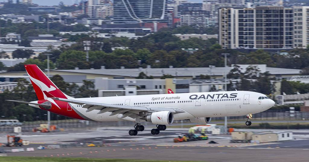 澳洲航空飛機在機場跑道滑行，背後有城市天際線