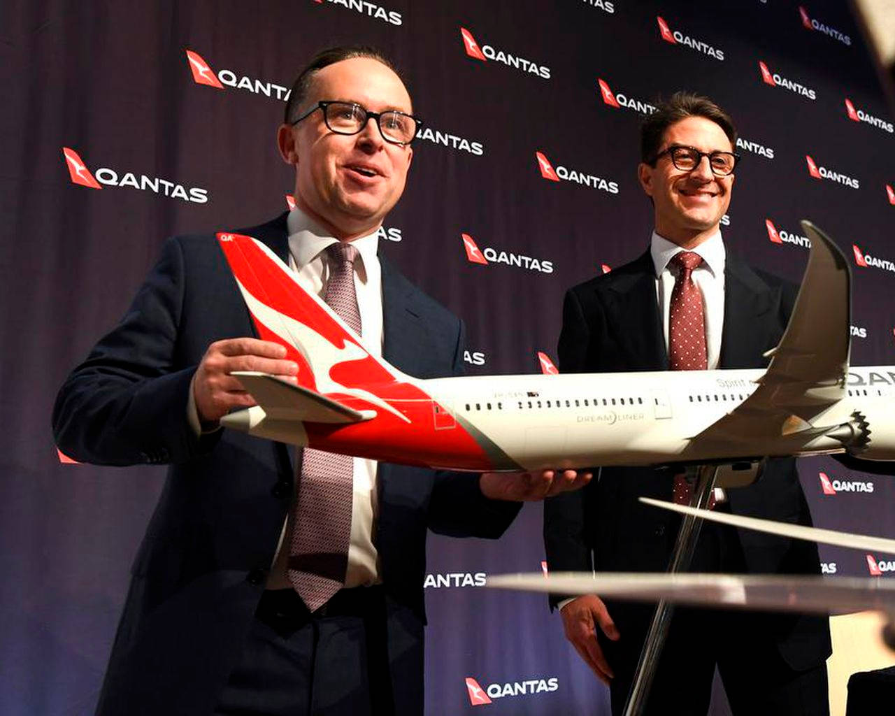 兩名商人在記者會上手持澳洲航空飛機模型。