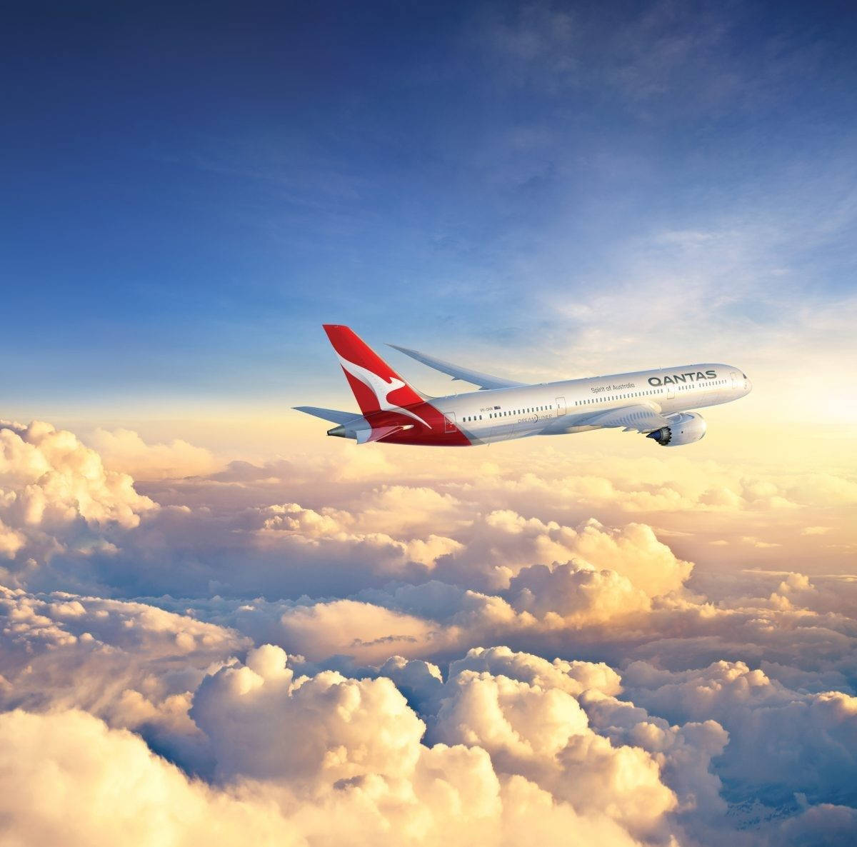 澳洲航空飛機在夕陽下飛越金色雲層。