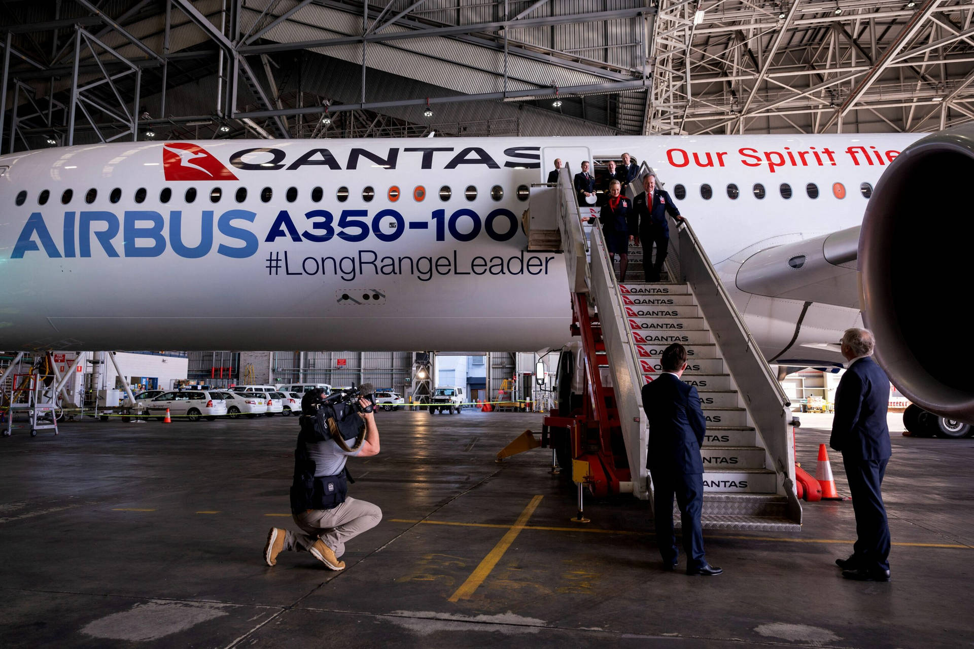 Qantas Airbus A350-100 飛機在機庫內，人們登機，攝影師捕捉場景。