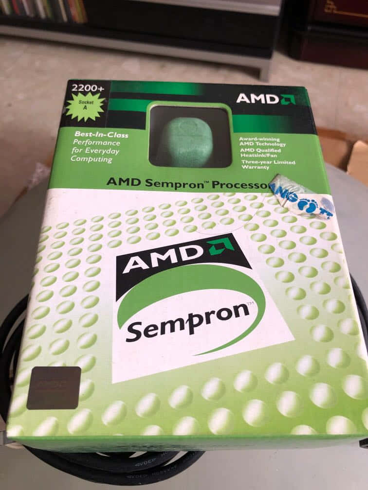 AMD Sempron 處理器盒，綠色和白色設計，窗口內可見 CPU。