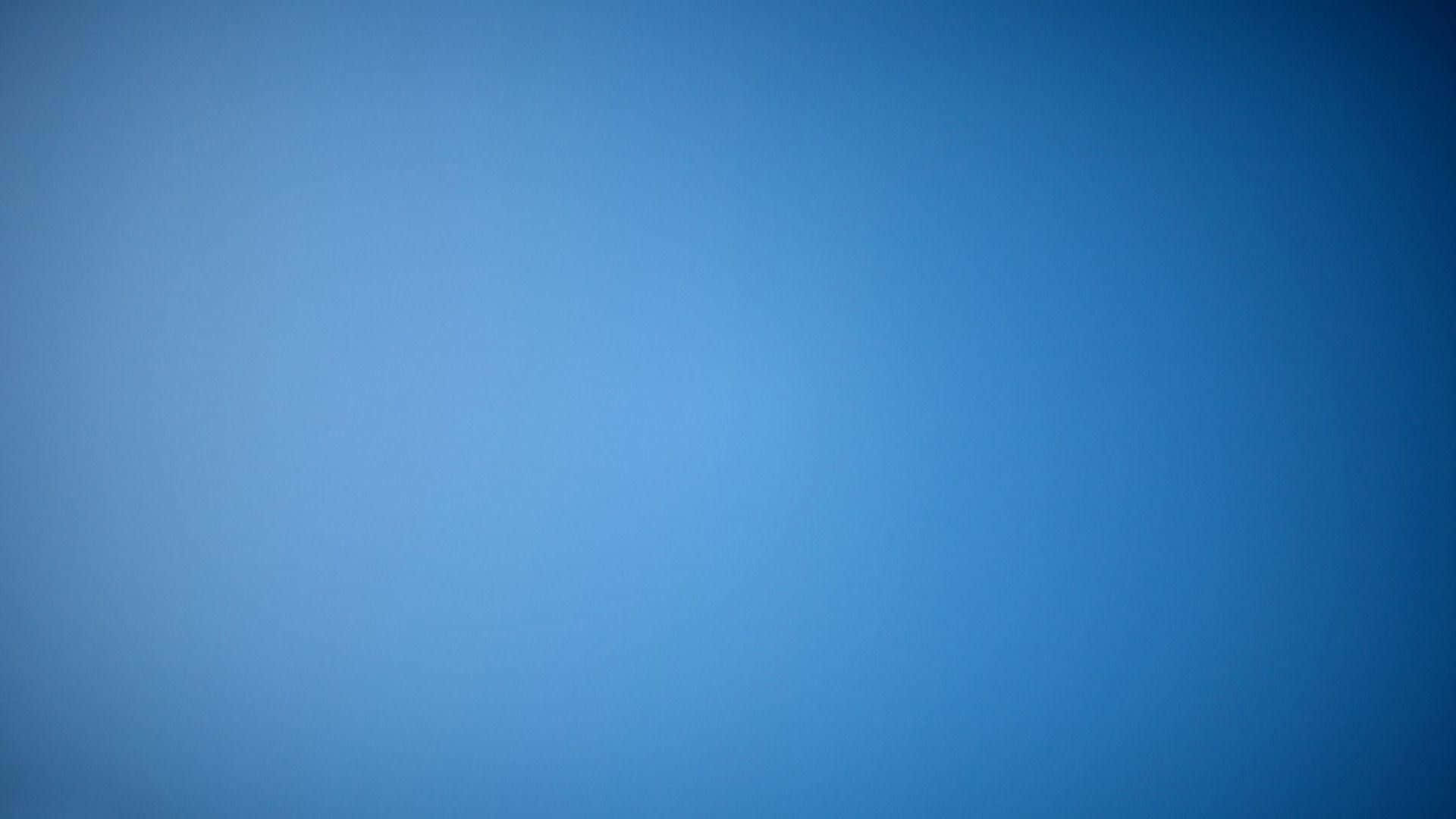 濃郁深藍漸層 壁紙 — 一片寧靜的漸變藍天，從淺藍過渡到深藍，帶有柔和的大氣薄霧。