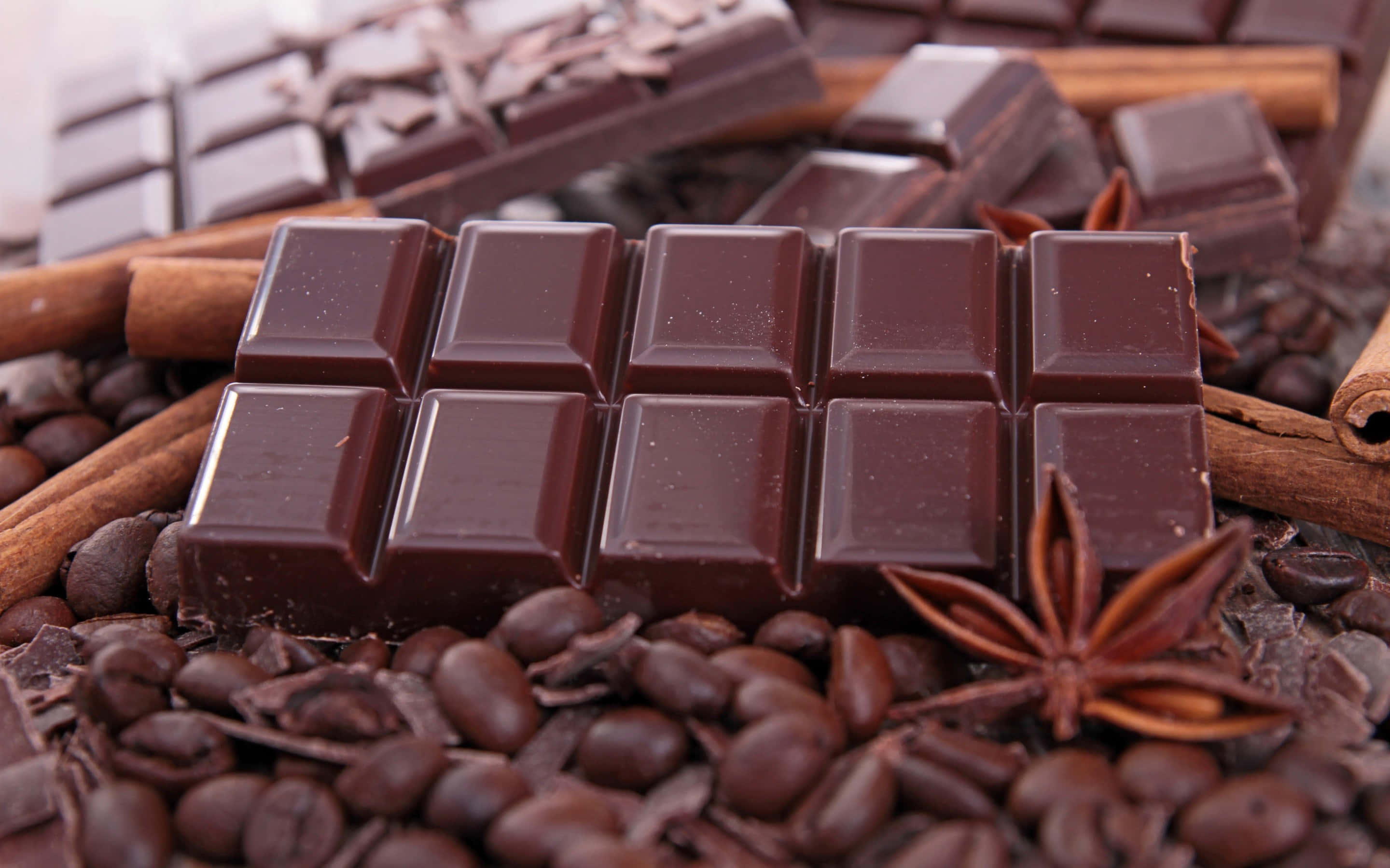 Dark Chocolate 桌布 壁紙 — 濃郁黑朱古力條 nestled 在咖啡豆、肉桂棒和八角之中，呈現奢華的特寫。