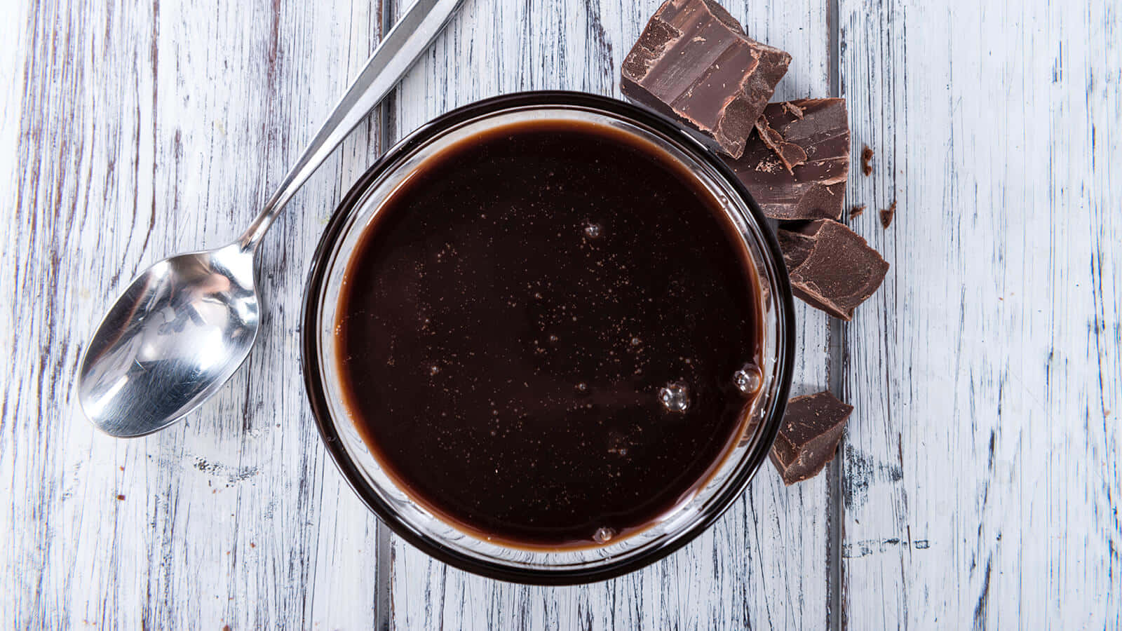 Dark Chocolate 桌布 壁紙 — 濃郁黑朱古力醬放在玻璃碗中，配上碎朱古力塊和湯匙，置於風化白色木面上。