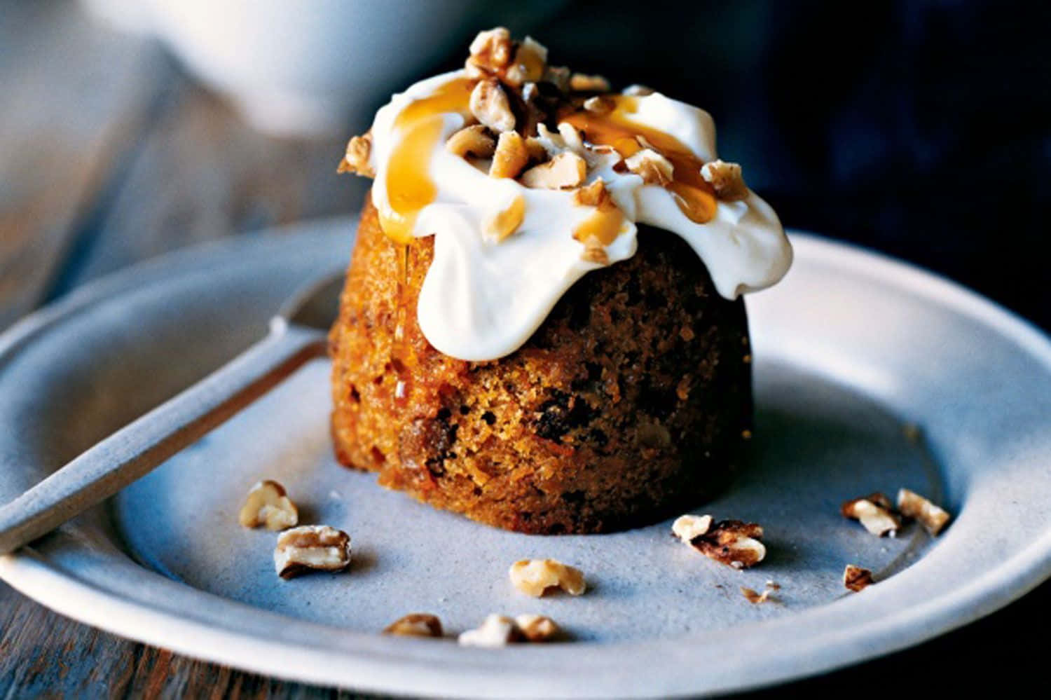 Winter Desserts 桌布 壁紙 — 濕潤嘅焦糖核桃蛋糕，上面有忌廉同醬汁，放喺鄉村風格嘅碟上，周圍撒咗啲果仁。